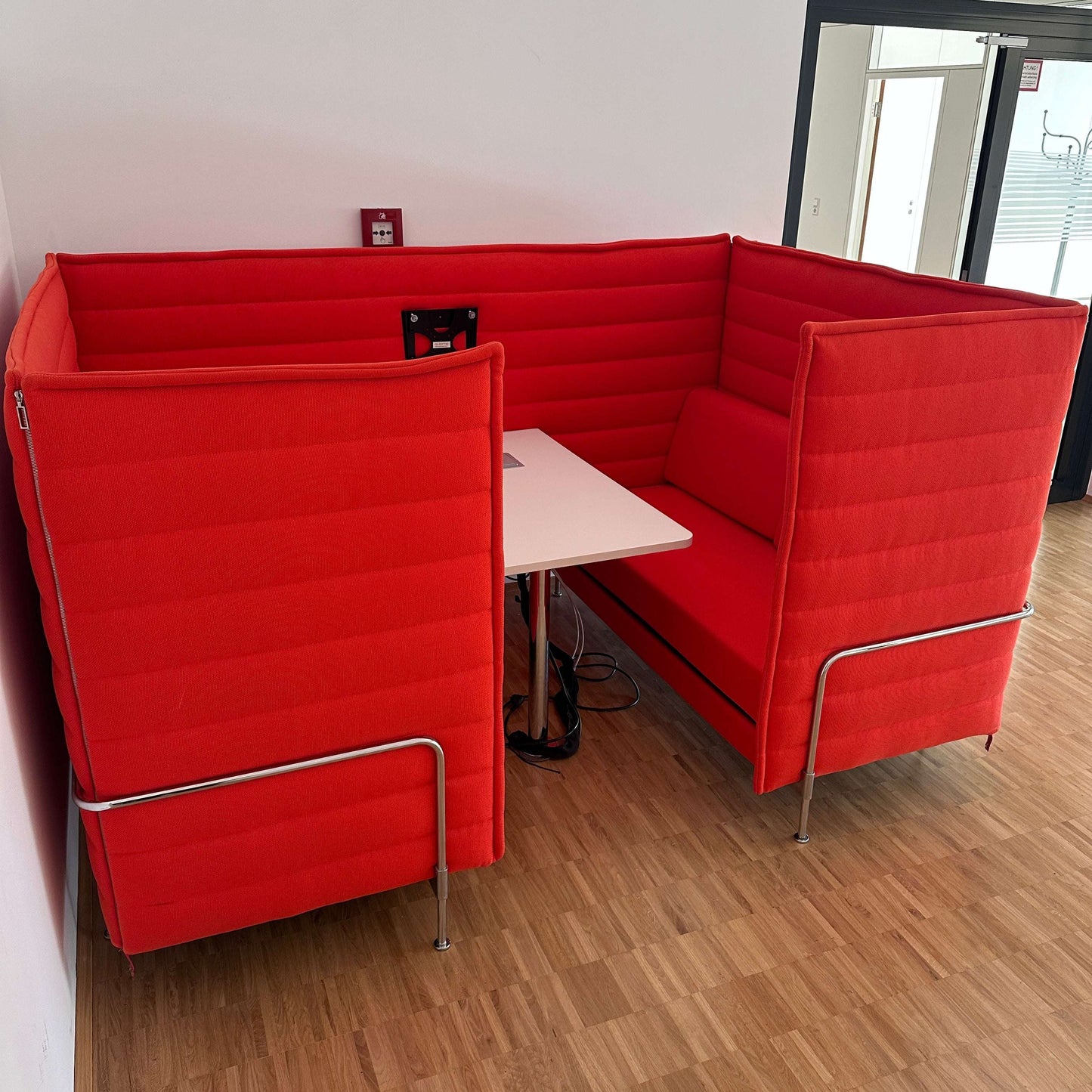 Vitra Alcove Cabin 2-Sitzer Highback in hellrot mit gepolsterten Seitenwänden, Arbeitsplatte und Monitorhalterung