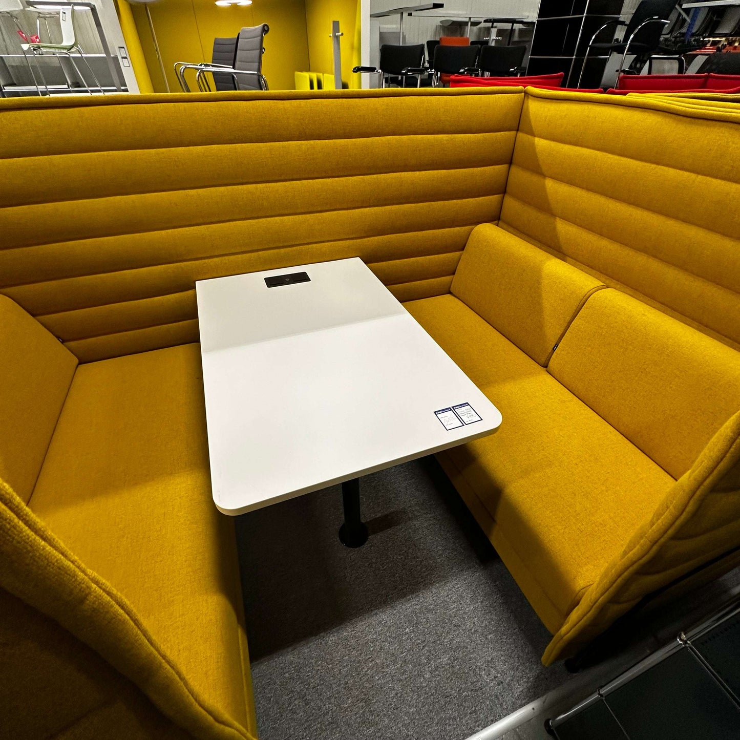 Vitra Alcove Cabin highback seating with integrated white worktable in mustard yellow upholstery
