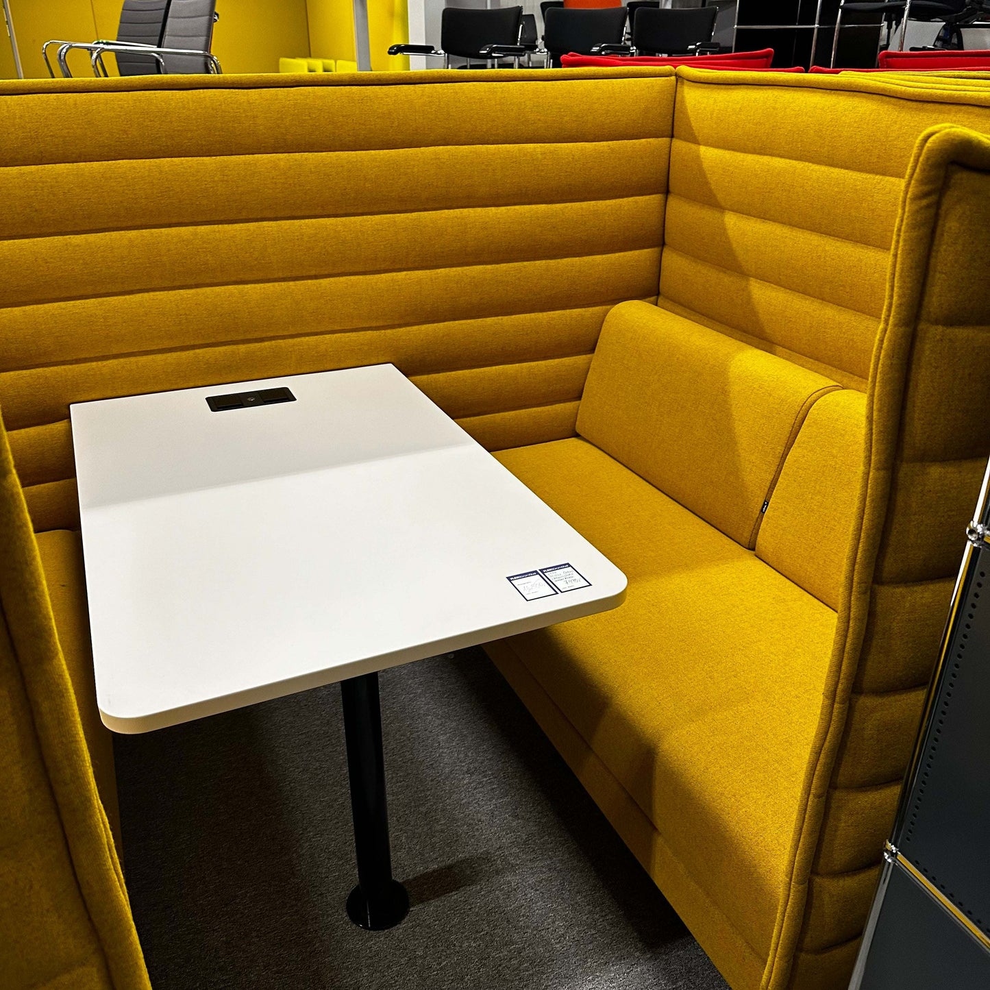 Vitra Alcove Cabin highback seating with white worktable in yellow upholstery and integrated power outlet