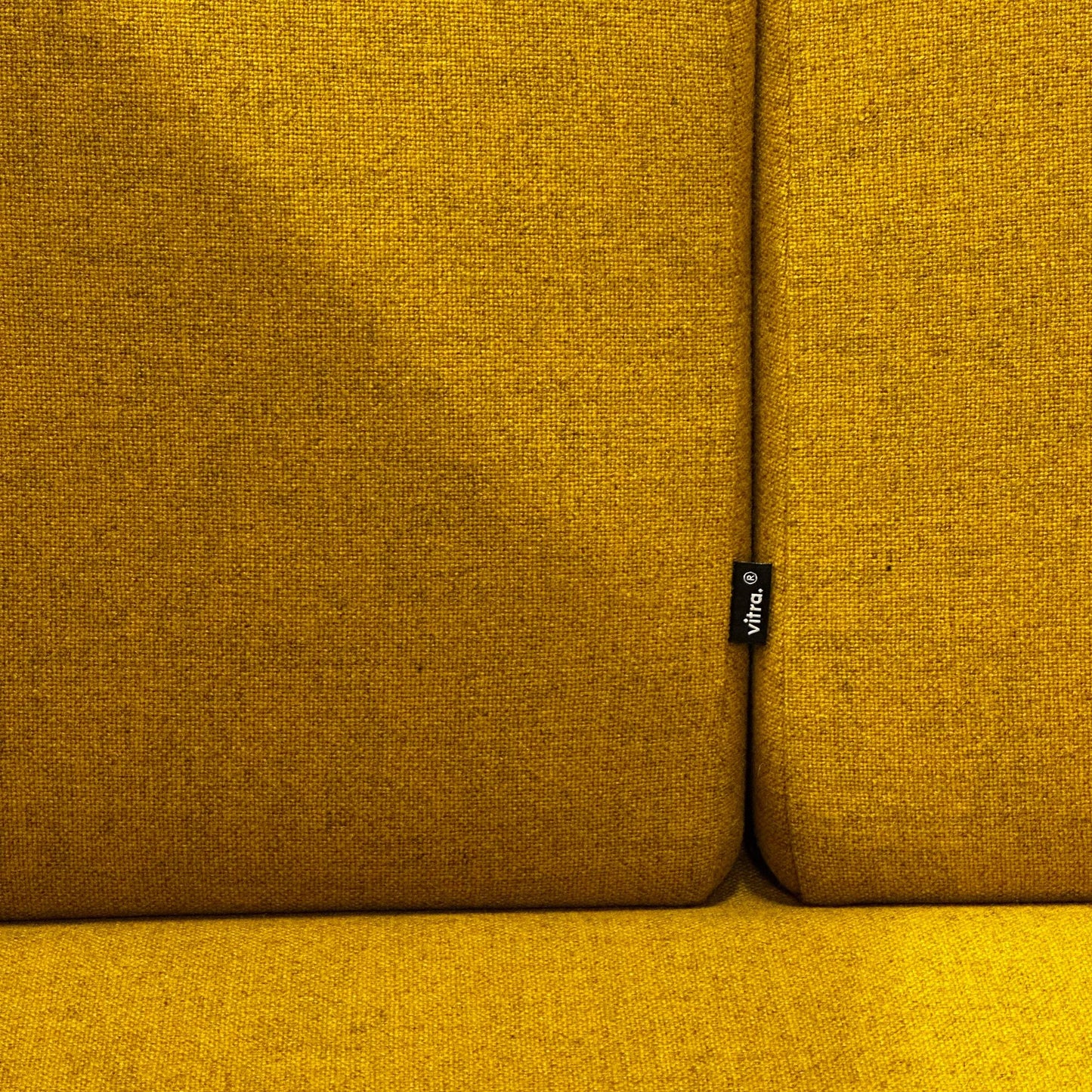 Close-up of mustard yellow fabric upholstery on Vitra Alcove Cabin Highback with visible Vitra brand tag