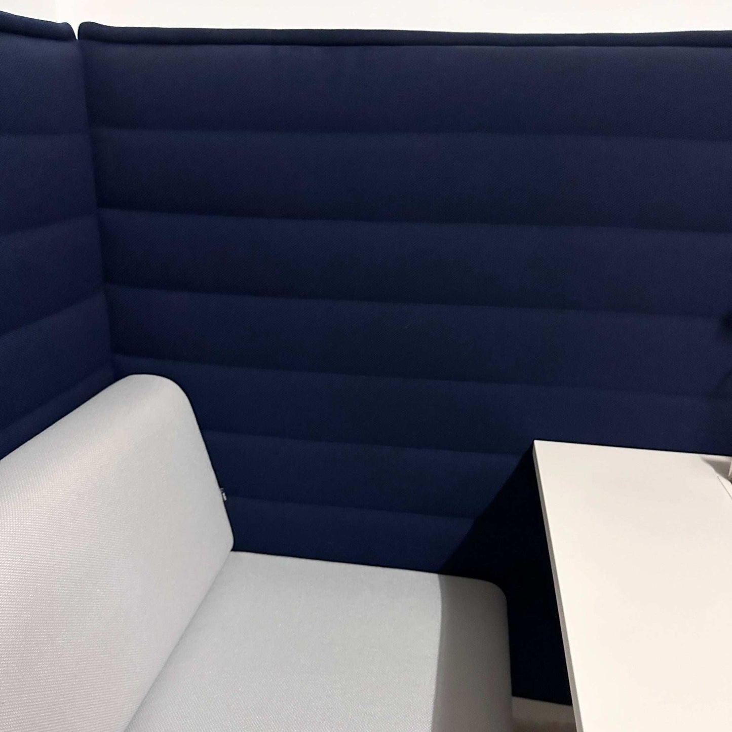 Vitra Alcove Cabin 2-Sitzer Highback mit dunkelblauem Akustikpaneel und grauem Sitz in Büroarbeitsumgebung