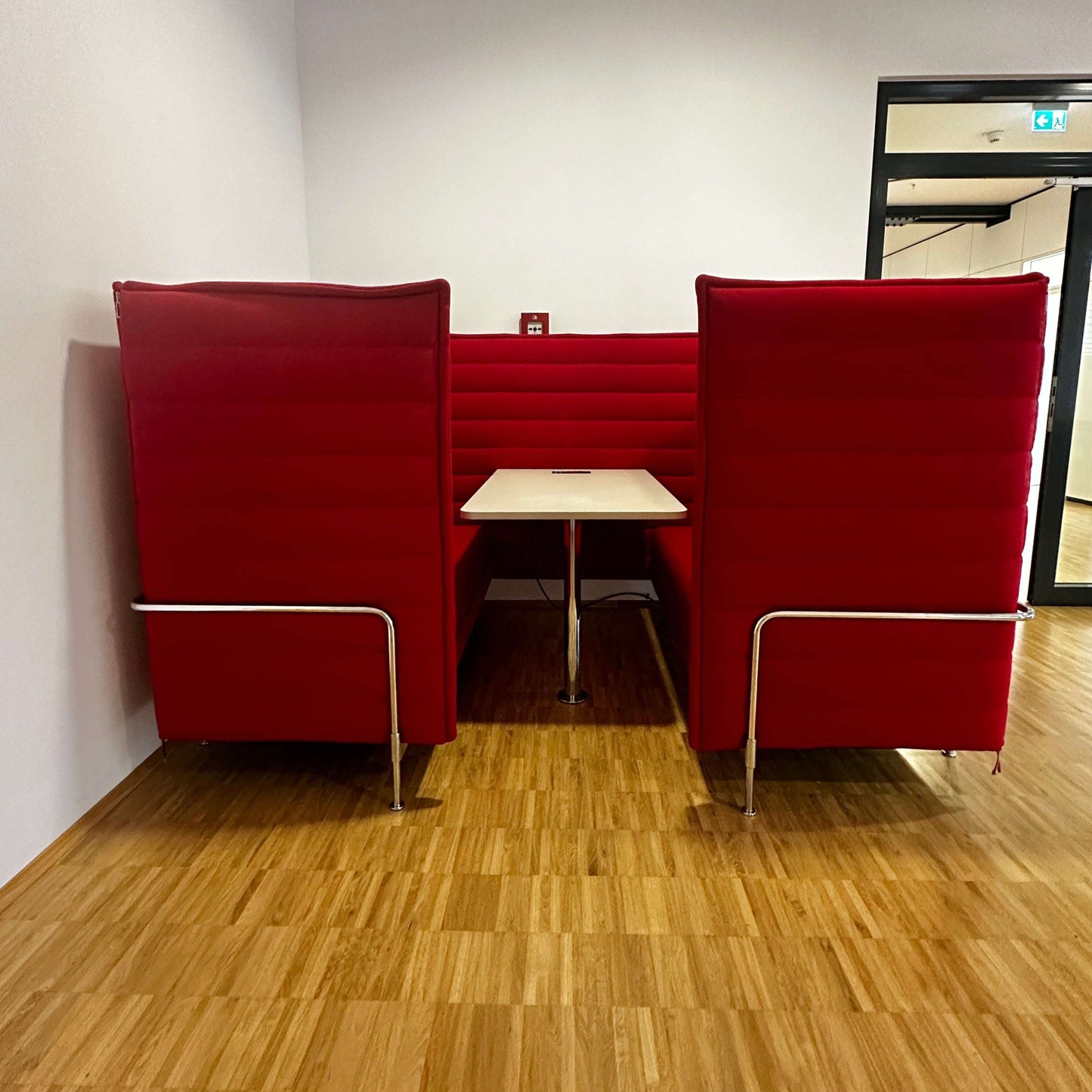 Vitra Alcove Cabin Highback rotes 2-Sitzer Sofa mit Arbeitsplatte und schalldämpfenden gepolsterten Paneelen in Büroumgebung