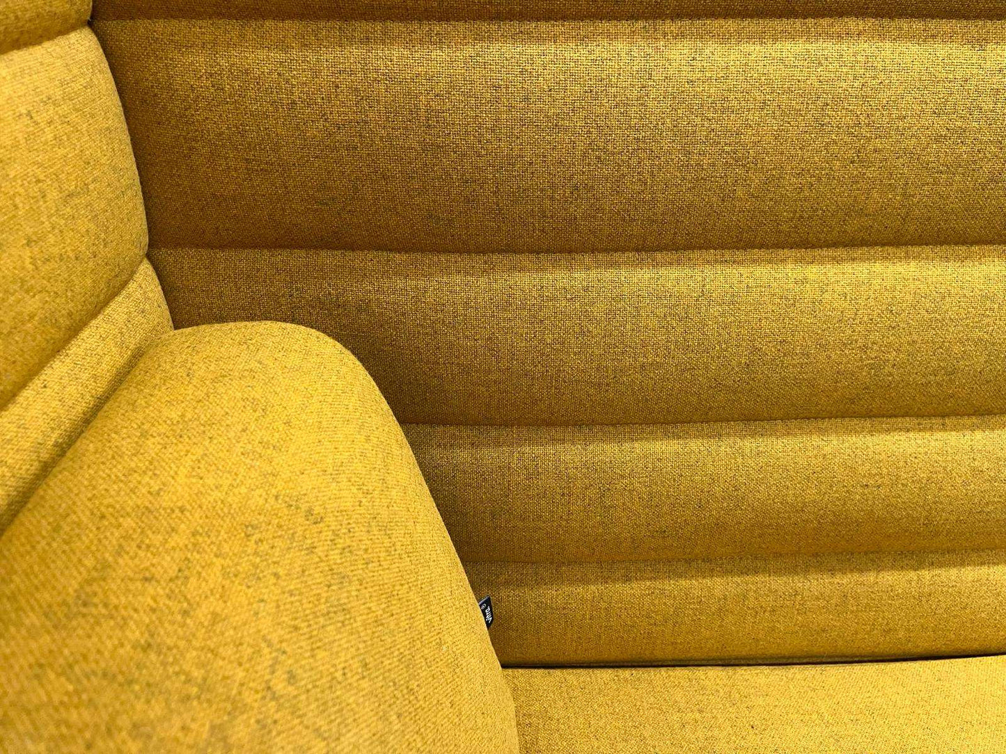 Close-up of Vitra Alcove Highback Work in vibrant yellow upholstery with textured fabric and horizontal panel design