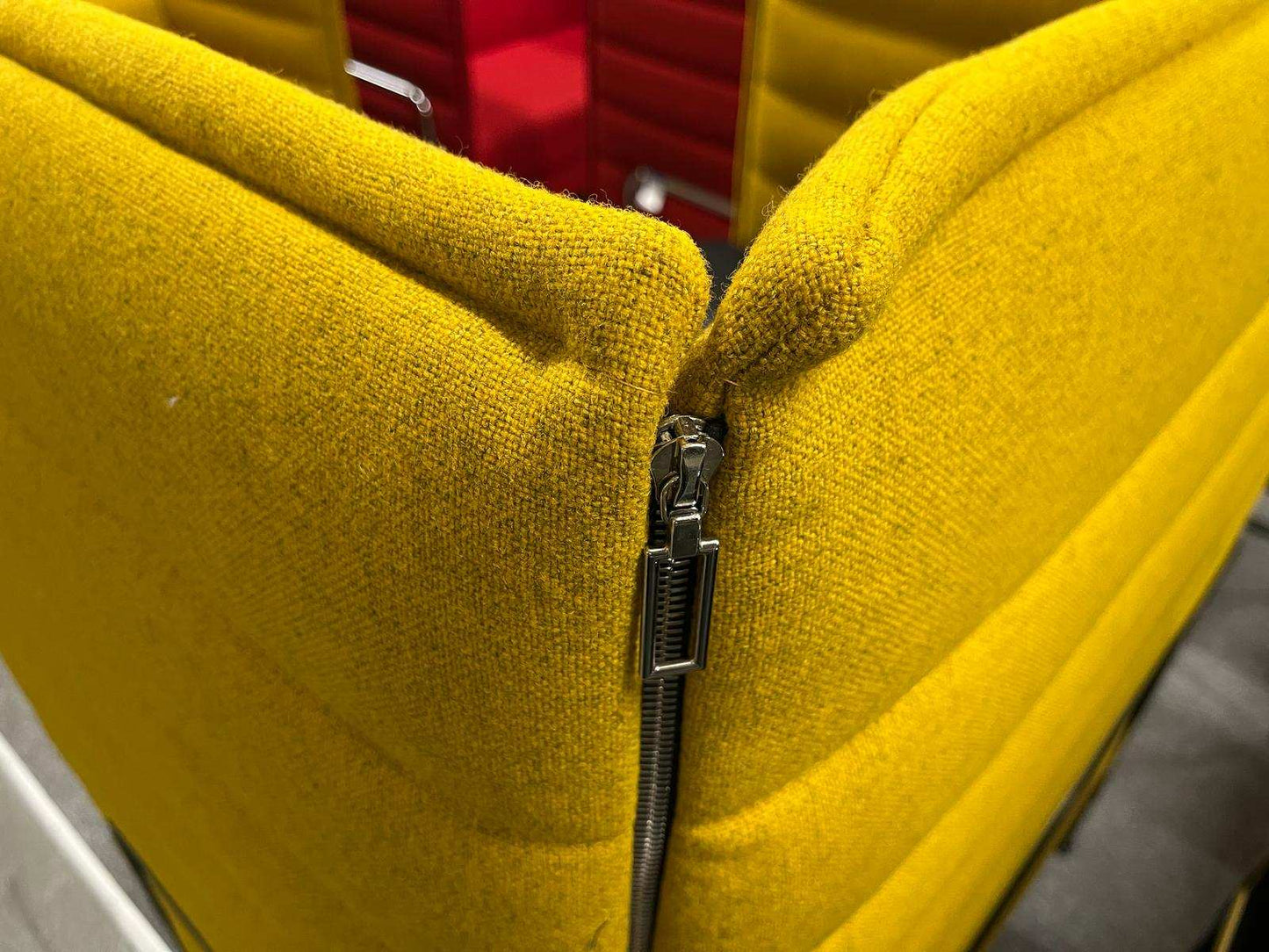 Close-up of yellow Vitra Alcove Highback work chair with visible zipper detail and textured fabric upholstery