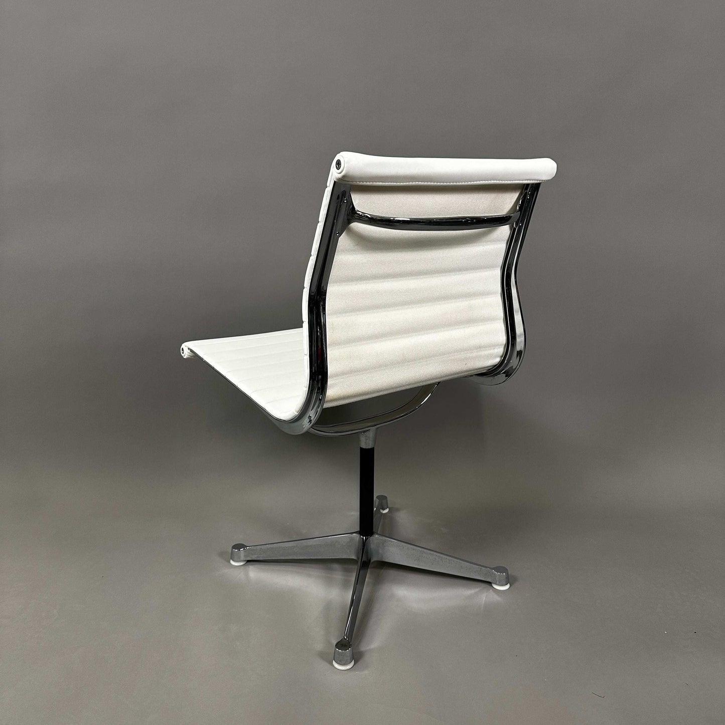 Vitra EA 101 chair in white leather with aluminum frame, non-swiveling and armless design.