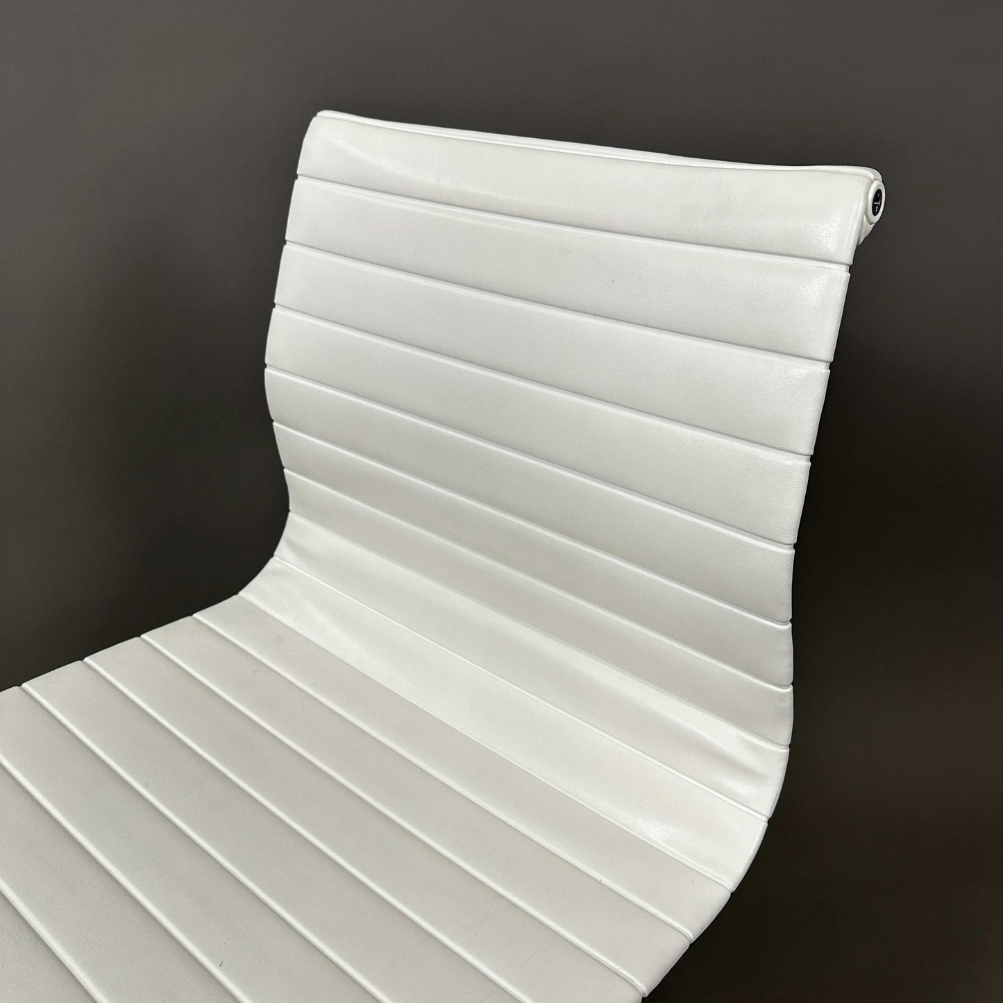 Vitra EA 101 white leather office chair with aluminum frame and no armrests.
