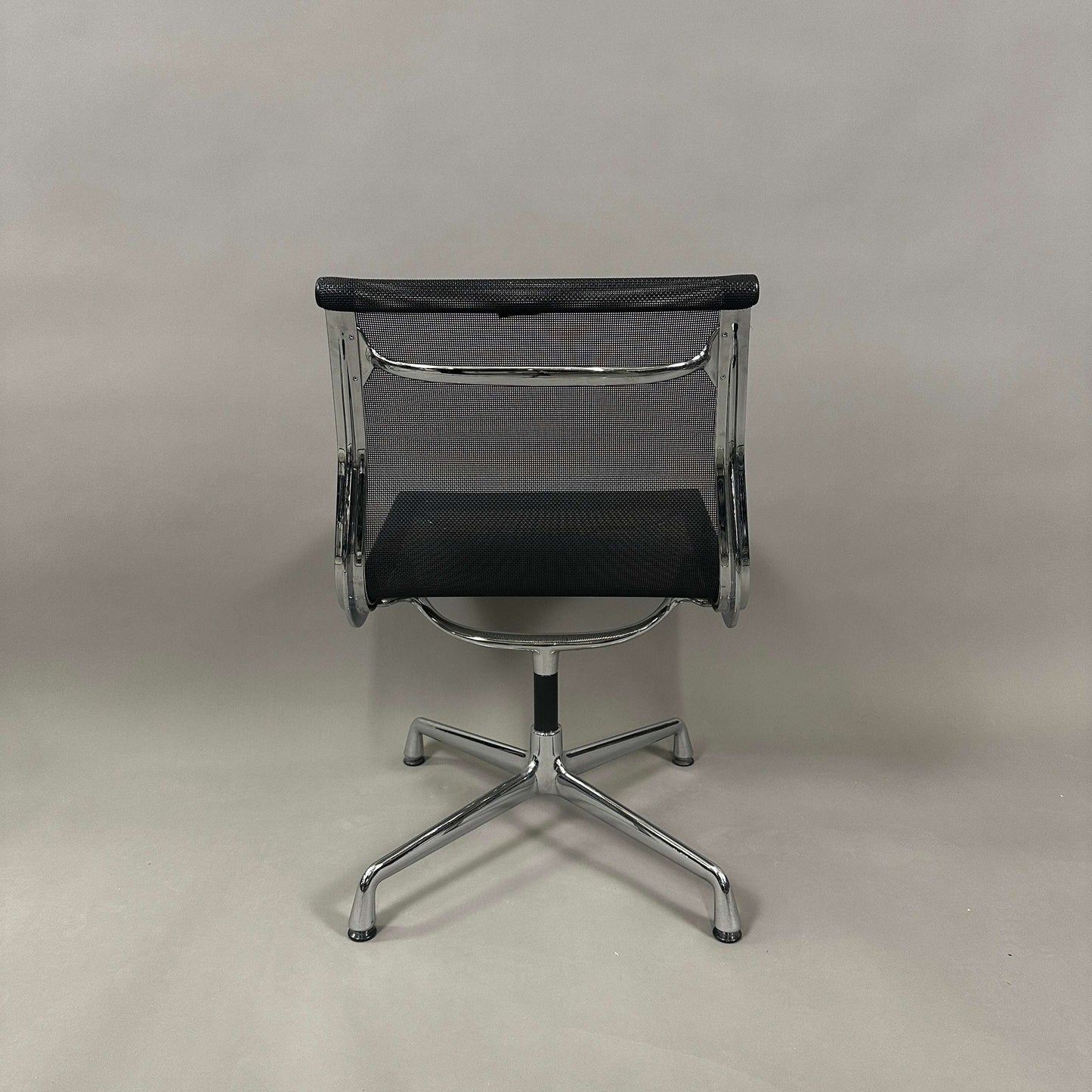 Vitra EA 106 Bürostuhl mit schwarzem Netzbezug und drehbarem Aluminiumgestell von hinten fotografiert