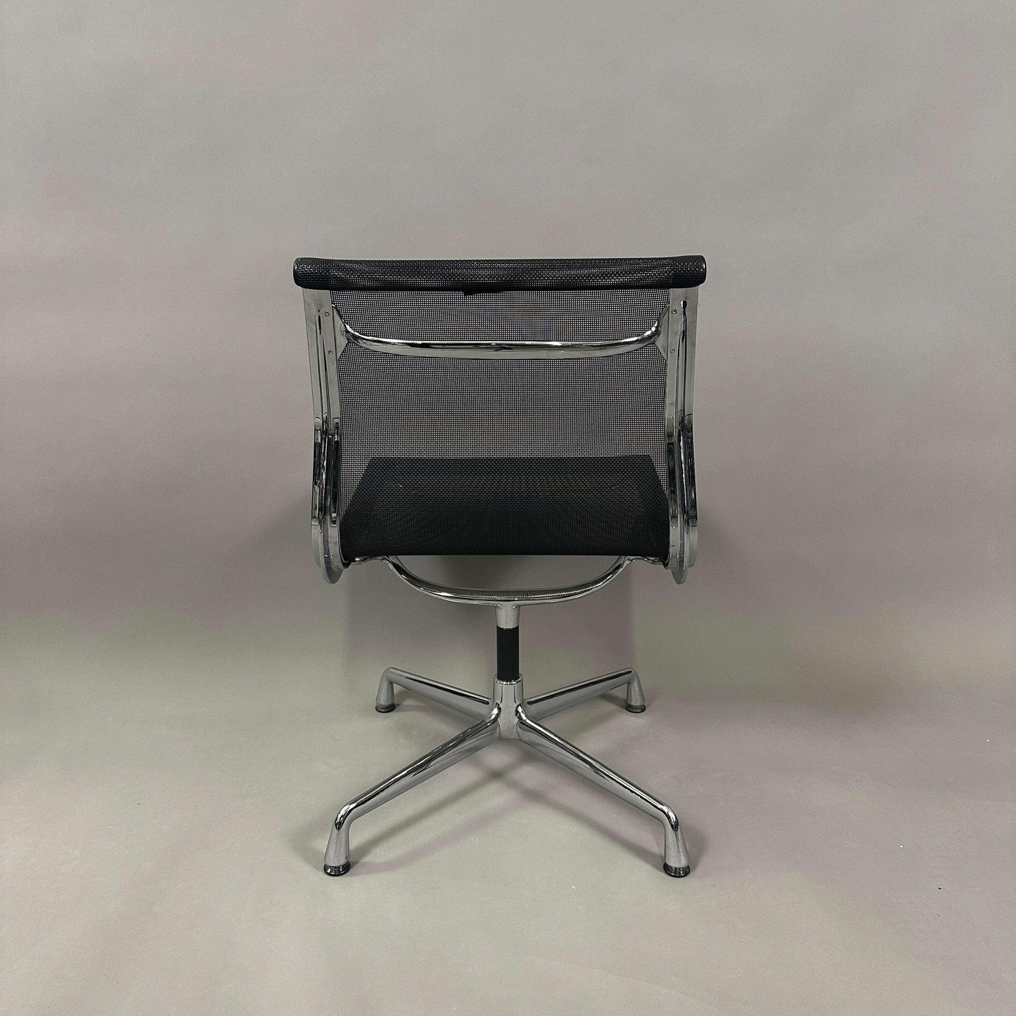 Vitra EA 106 Bürostuhl mit schwarzem Netzbezug und drehbarem Aluminiumgestell von hinten fotografiert