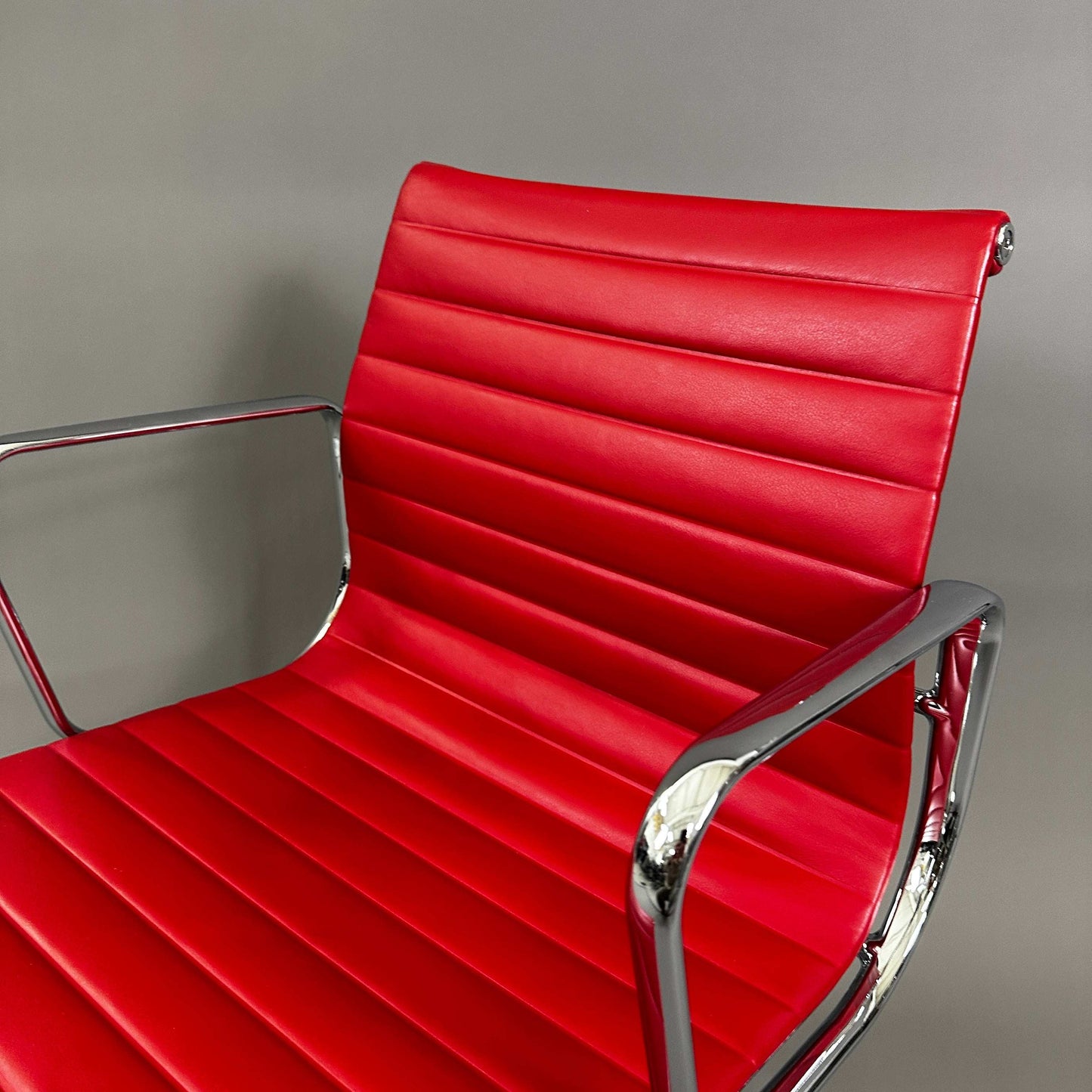 Vitra EA 108 red leather swivel chair with chrome frame
