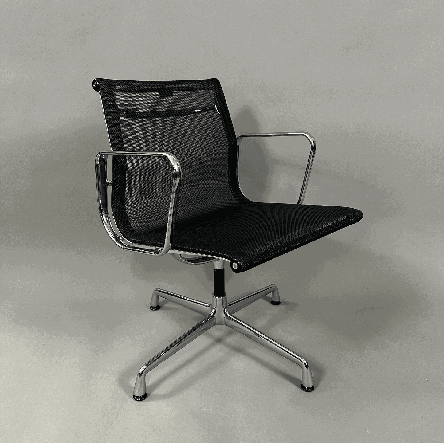 Vitra EA 108 swivel office chair with black mesh seat and chrome frame