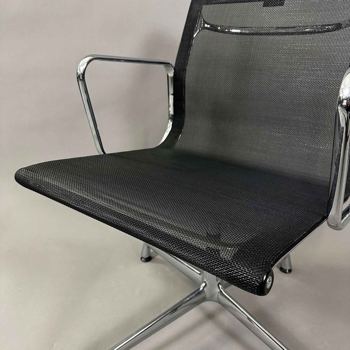 Vitra EA 108 black mesh swivel office chair with chrome armrests and base