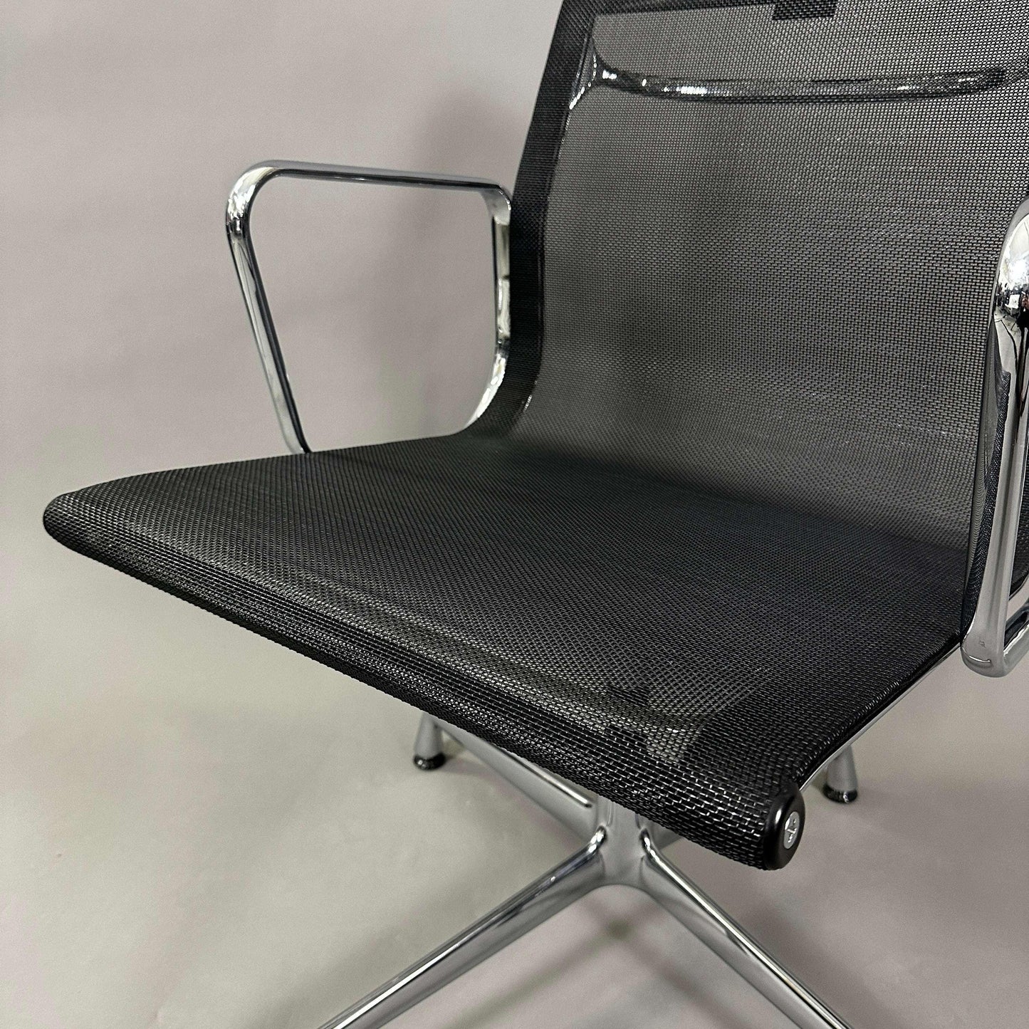 Vitra EA 108 black mesh swivel office chair with chrome armrests and base