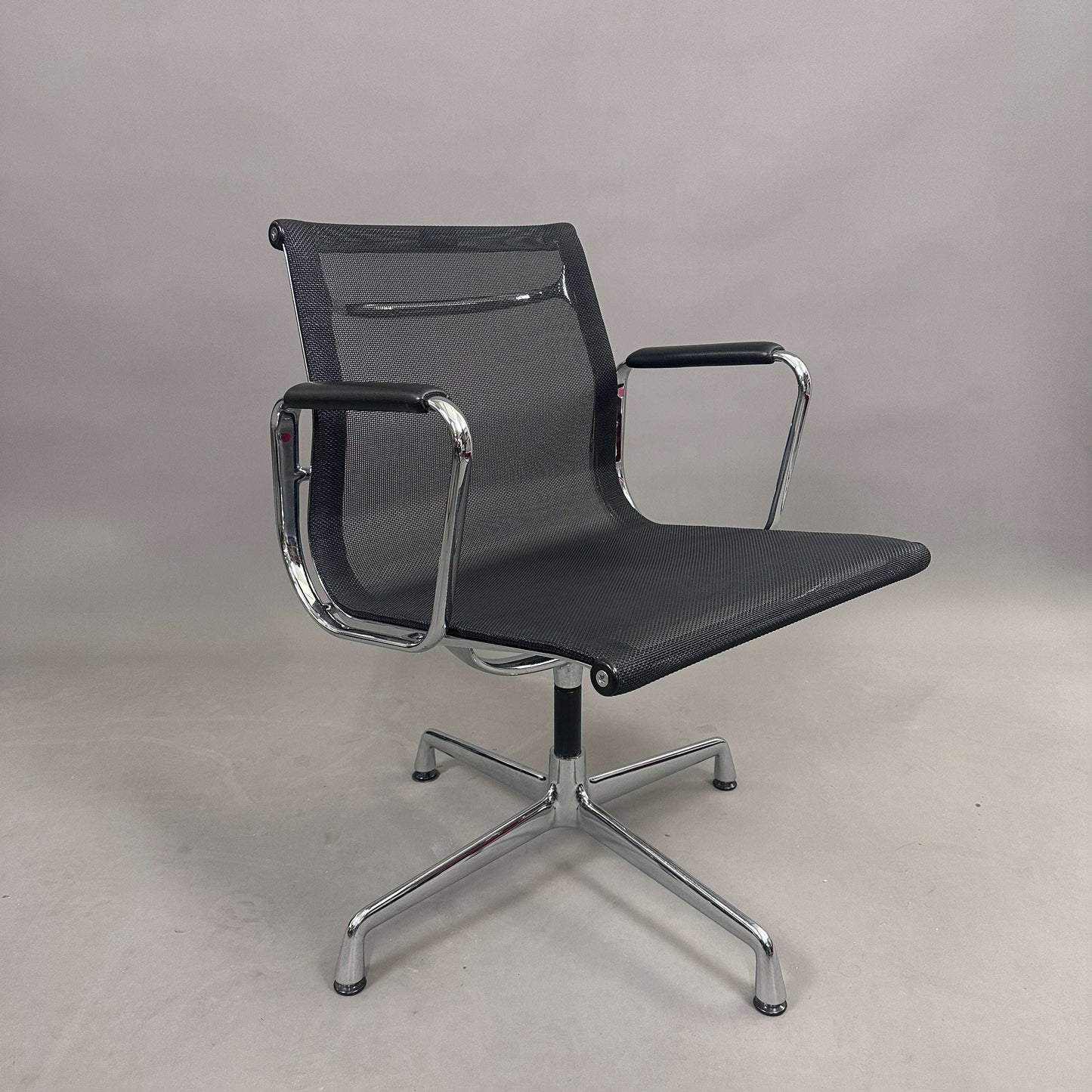 Vitra EA 108 swivel office chair with black mesh seat and chrome frame