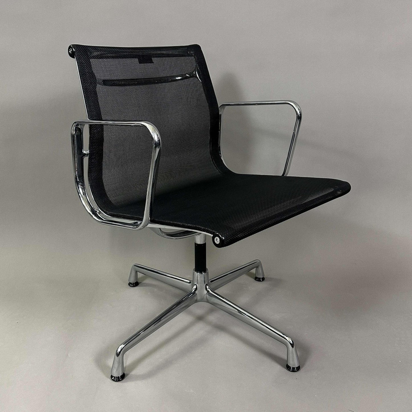 Vitra EA 108 black mesh swivel chair with chrome frame and armrests
