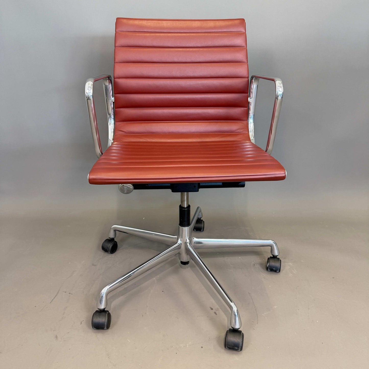 Vitra EA 117 Bürostuhl aus terracotta Premium Leder mit poliertem Aluminiumgestell und drehbarer Sitzfläche.
