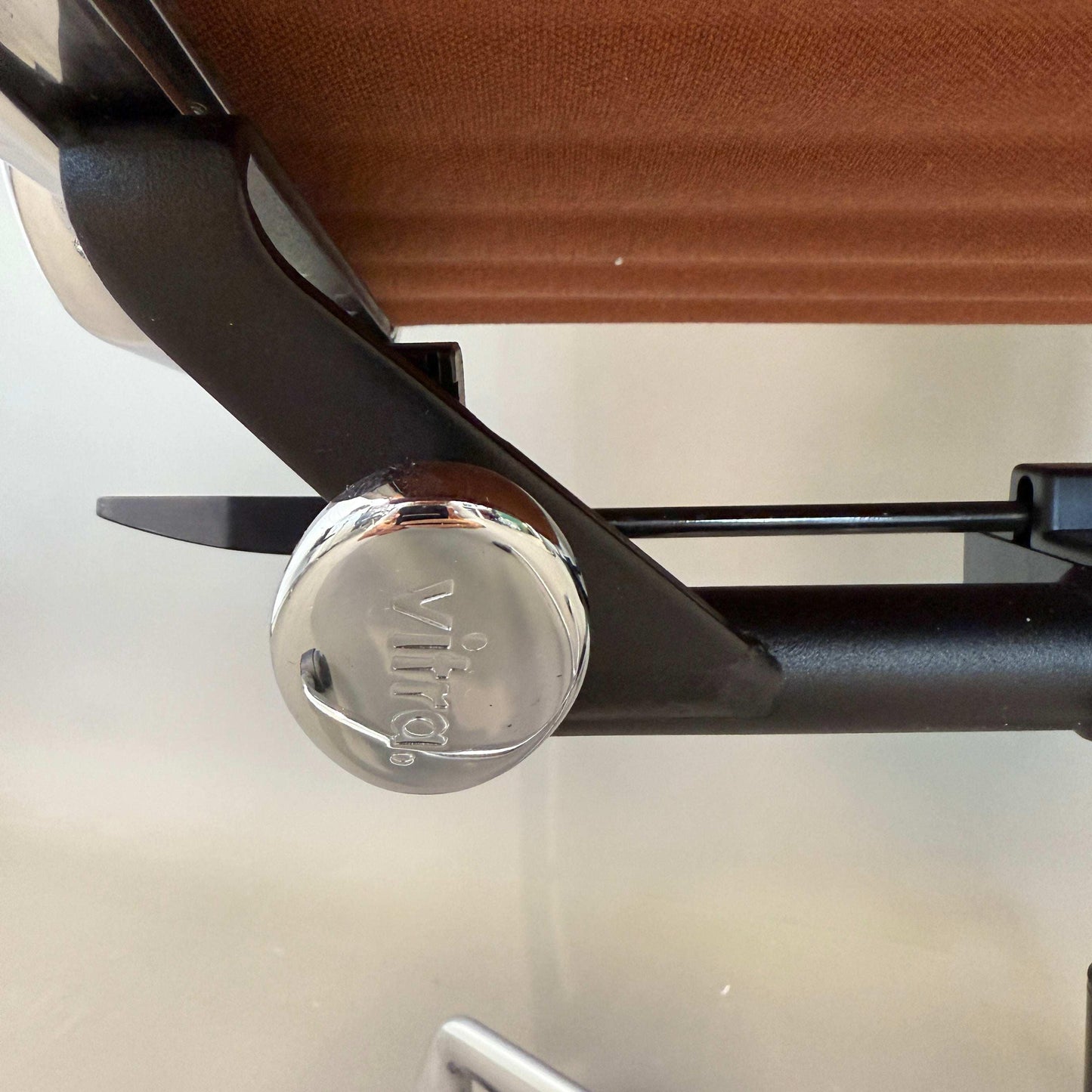 Vitra EA 117 Drehstuhl Detailaufnahme mit poliertem Aluminiumgestell und terracotta Premium Lederbezug