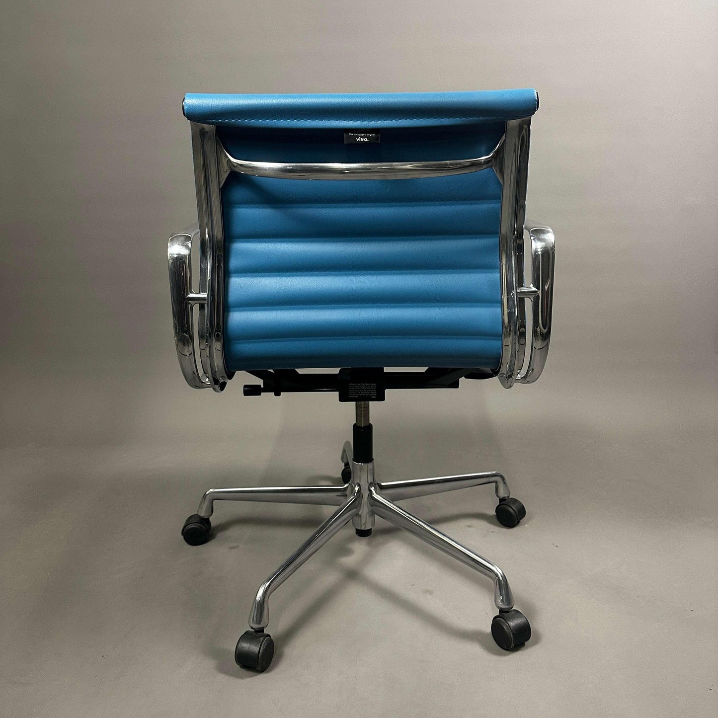 Vitra EA 117 Aluminium Bürostuhl mit blauem Vinylbezug und verstellbarer Rückenlehne von hinten gesehen