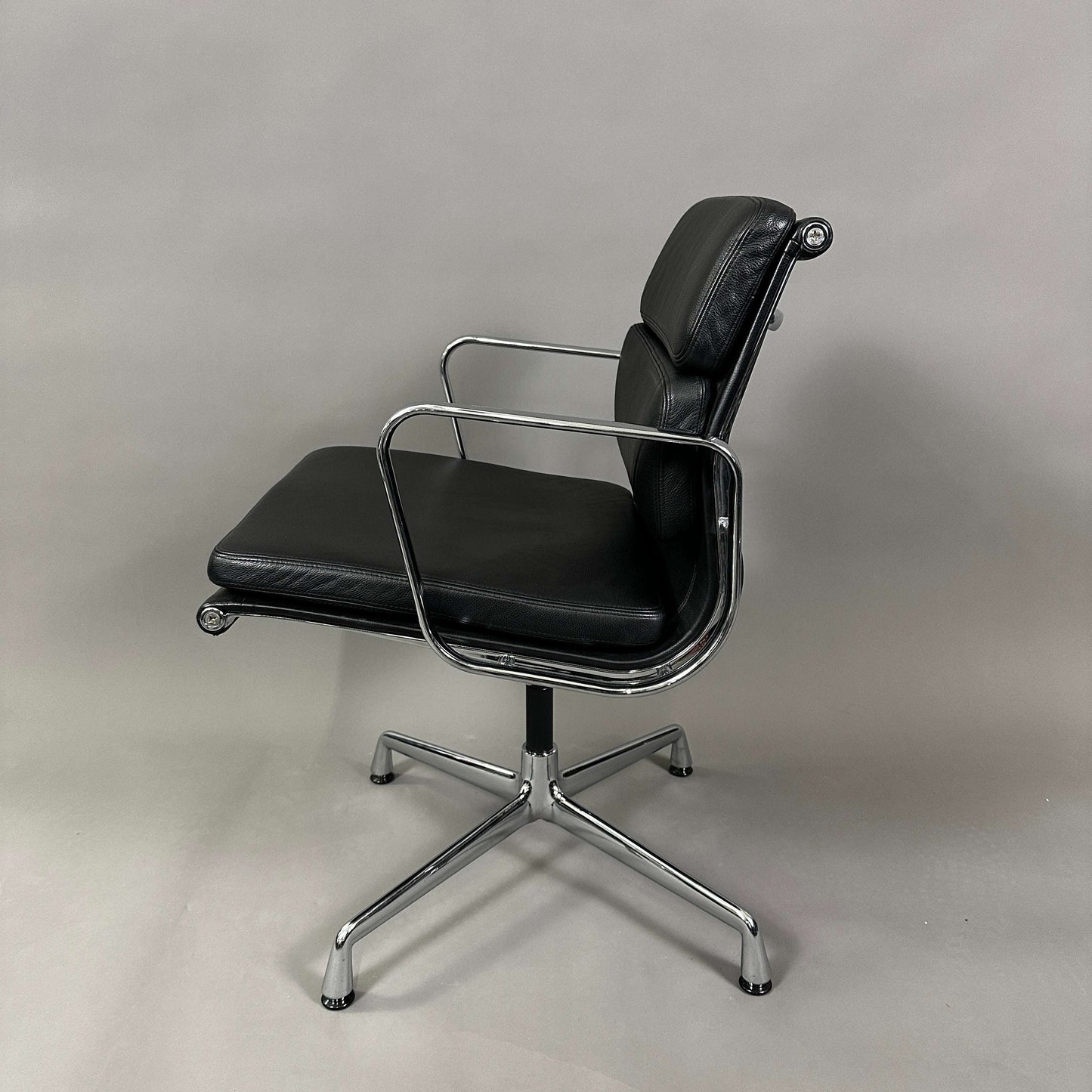 Vitra EA 208 black leather soft pad chair with chrome swivel frame.