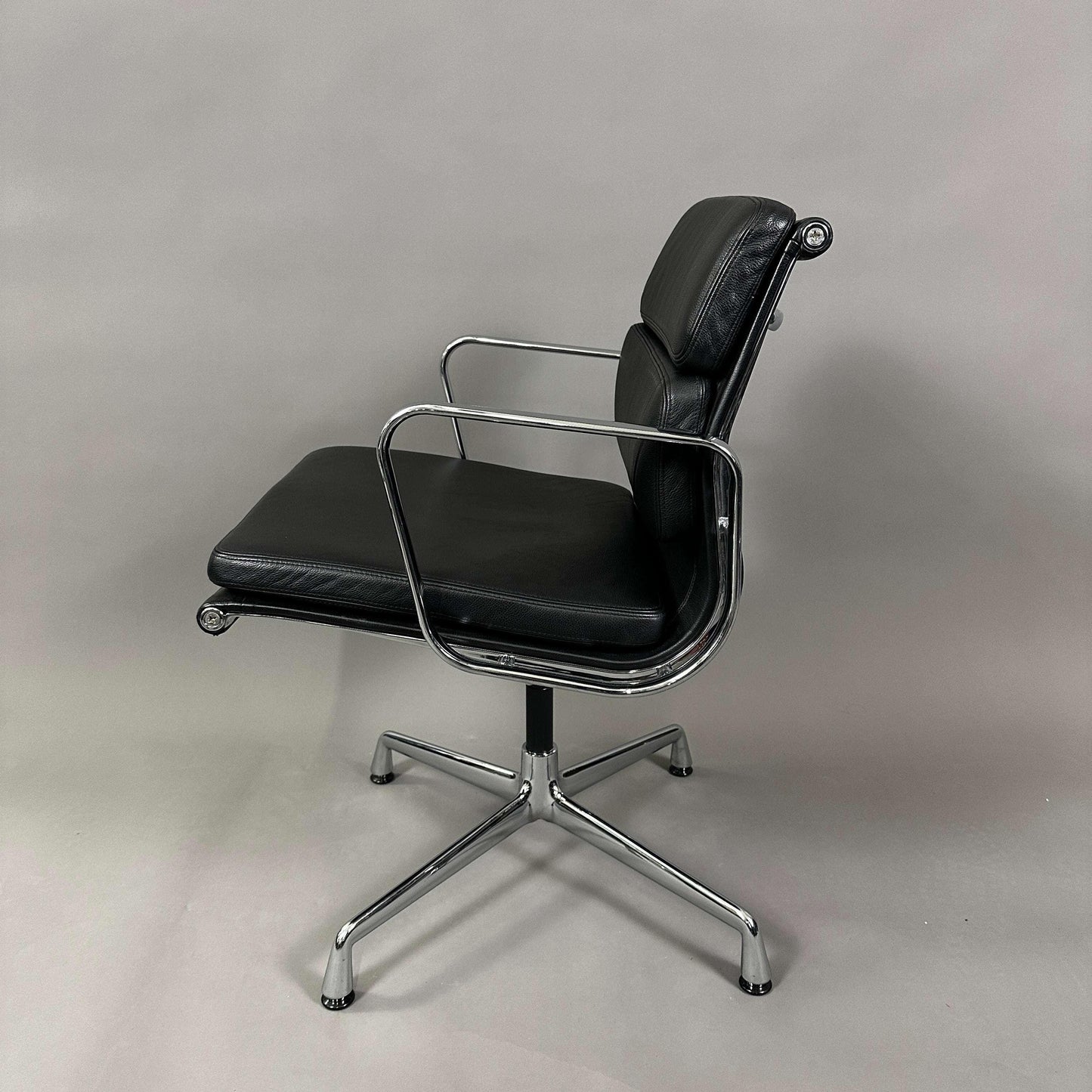 Vitra EA 208 black leather soft pad chair with chrome swivel frame.