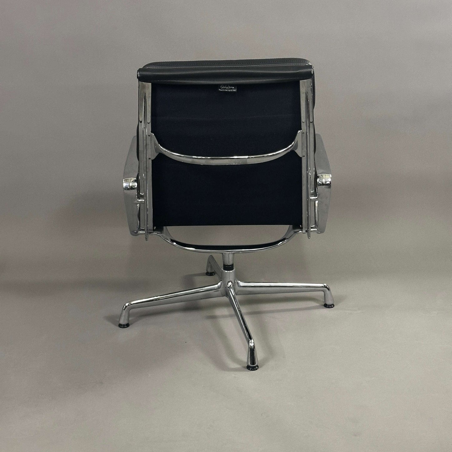 Back view of Vitra EA 216 swivel chair with black soft pad leather and aluminum frame