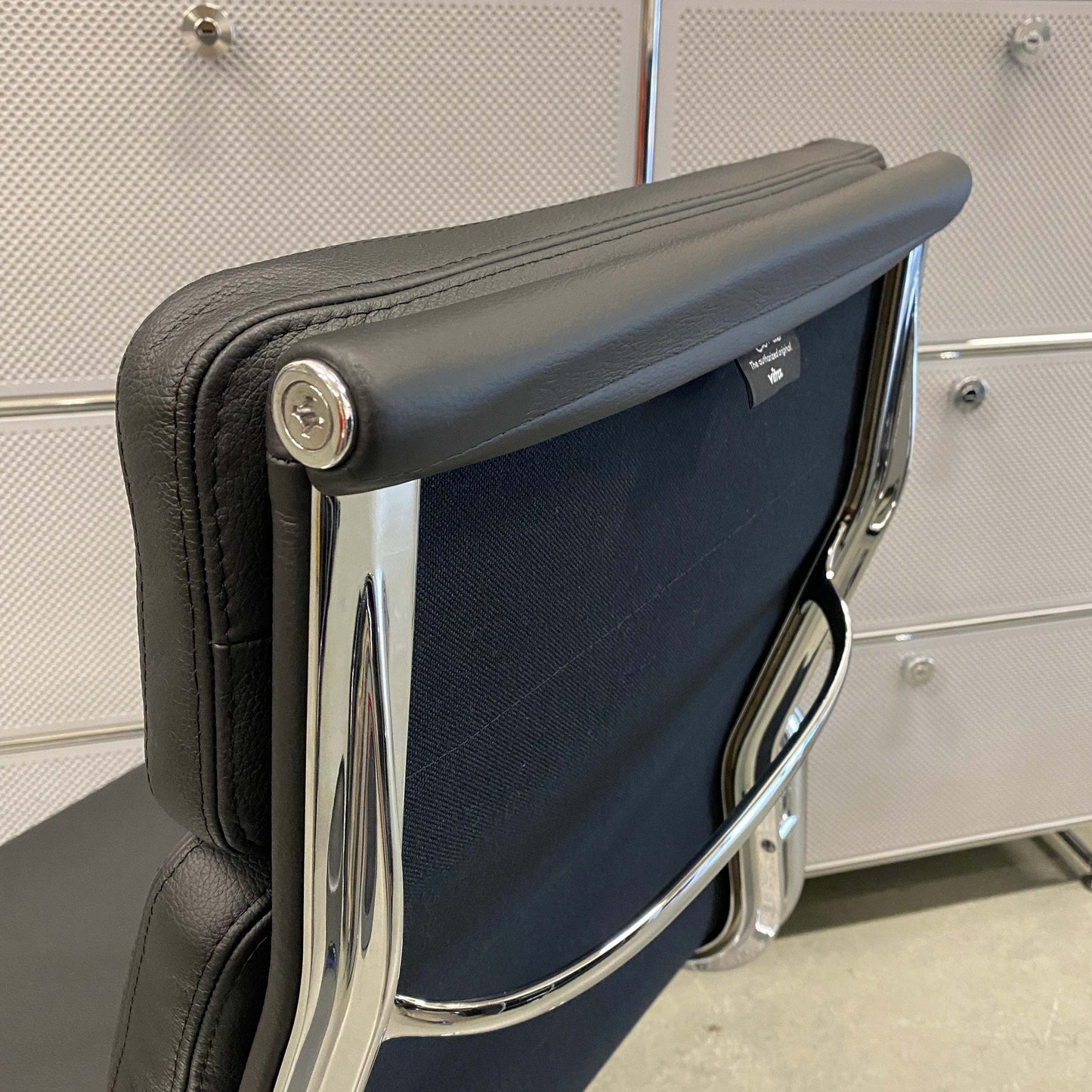 Back view of Vitra EA 219 black leather office chair with chrome frame and adjustable recline mechanism