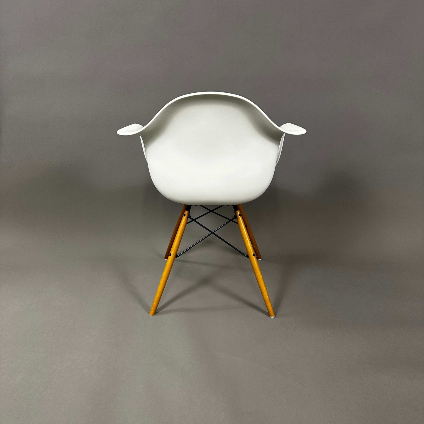 Vitra Eames Plastic Armchair weiß mit Holzgestell und rotem Sitzpolster