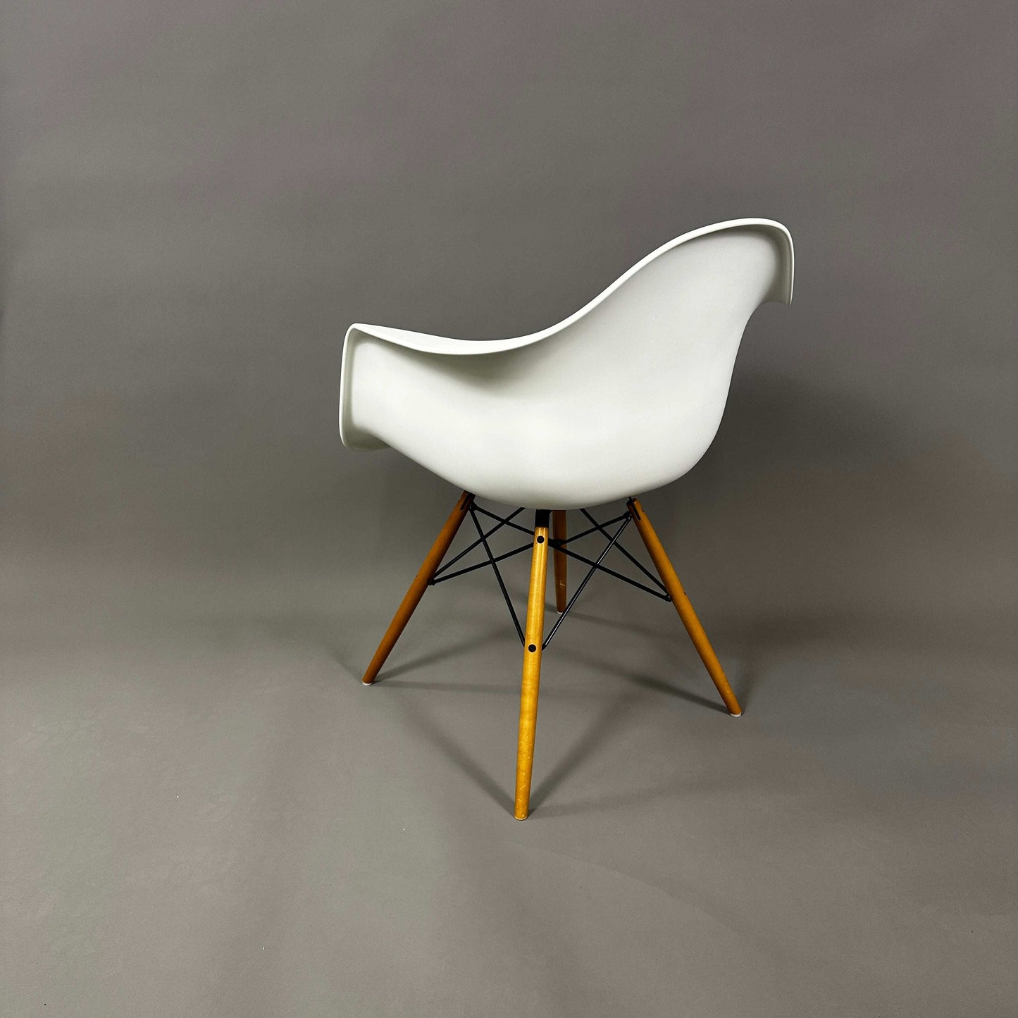 Vitra Eames Plastic Armchair weiß mit Holzgestell und Metallverstrebungen, moderner Designerstuhl