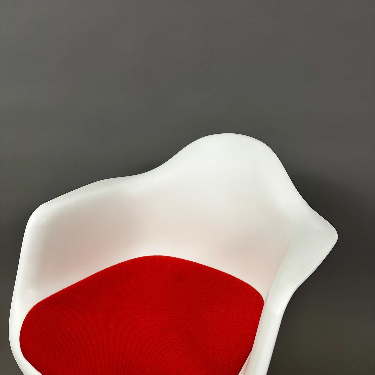 Vitra Eames Plastic Armchair mit weißer Sitzschale und rotem Hopsak Sitzpolster, Holzgestell mit Metallverstrebungen