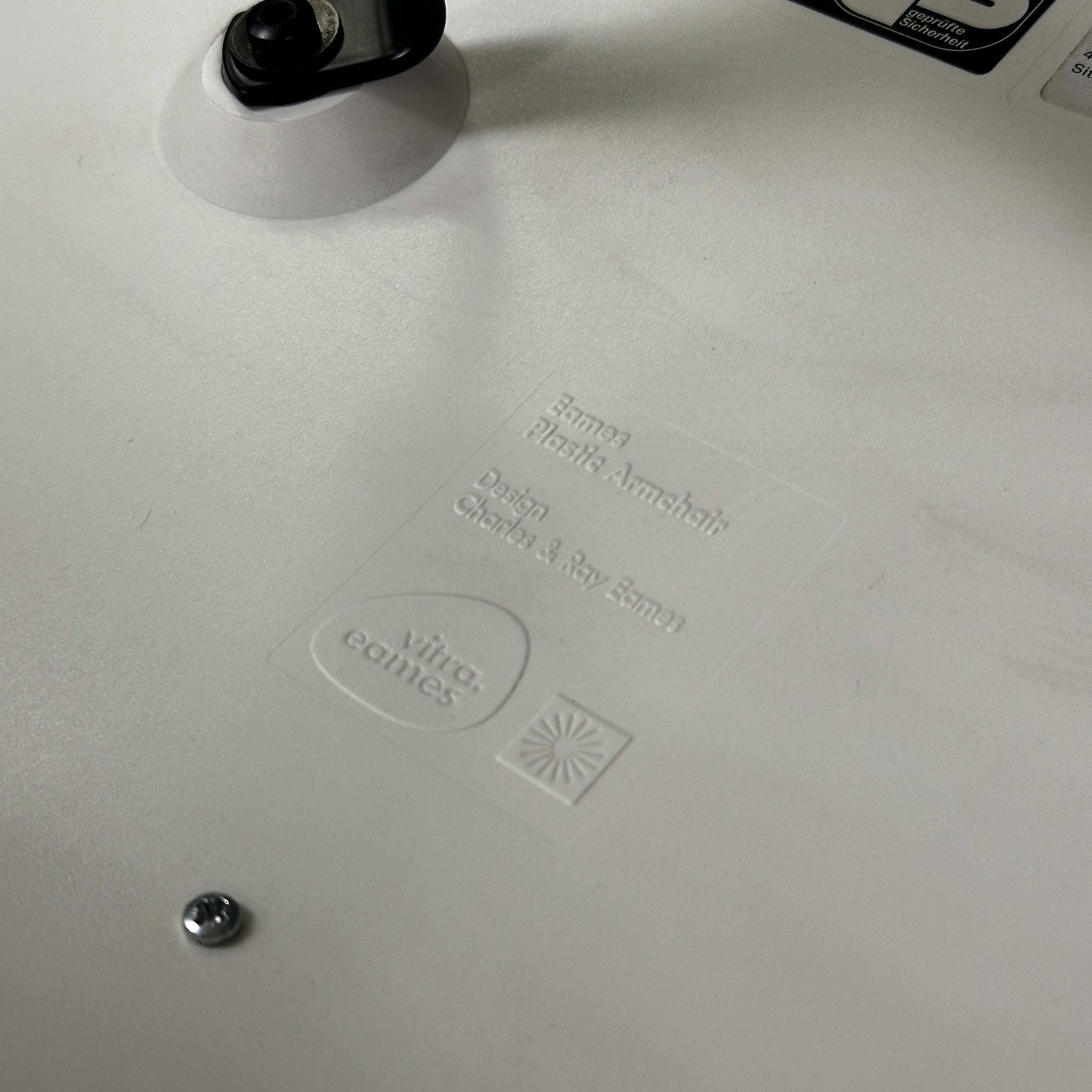 Vitra Eames Plastic Armchair weiße Sitzschale Detailprägung Herstellerlogo