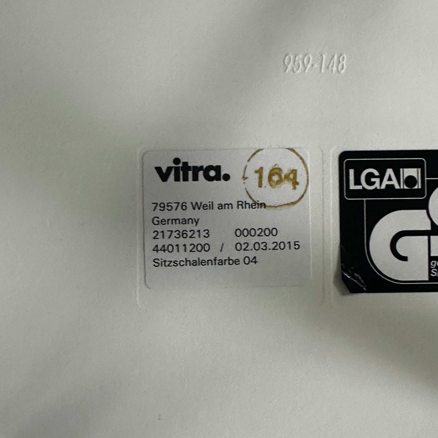 Vitra Eames Plastic Armchair weiß mit grünem Hopsak Sitzpolster und Holzgestell mit Metallverstrebungen