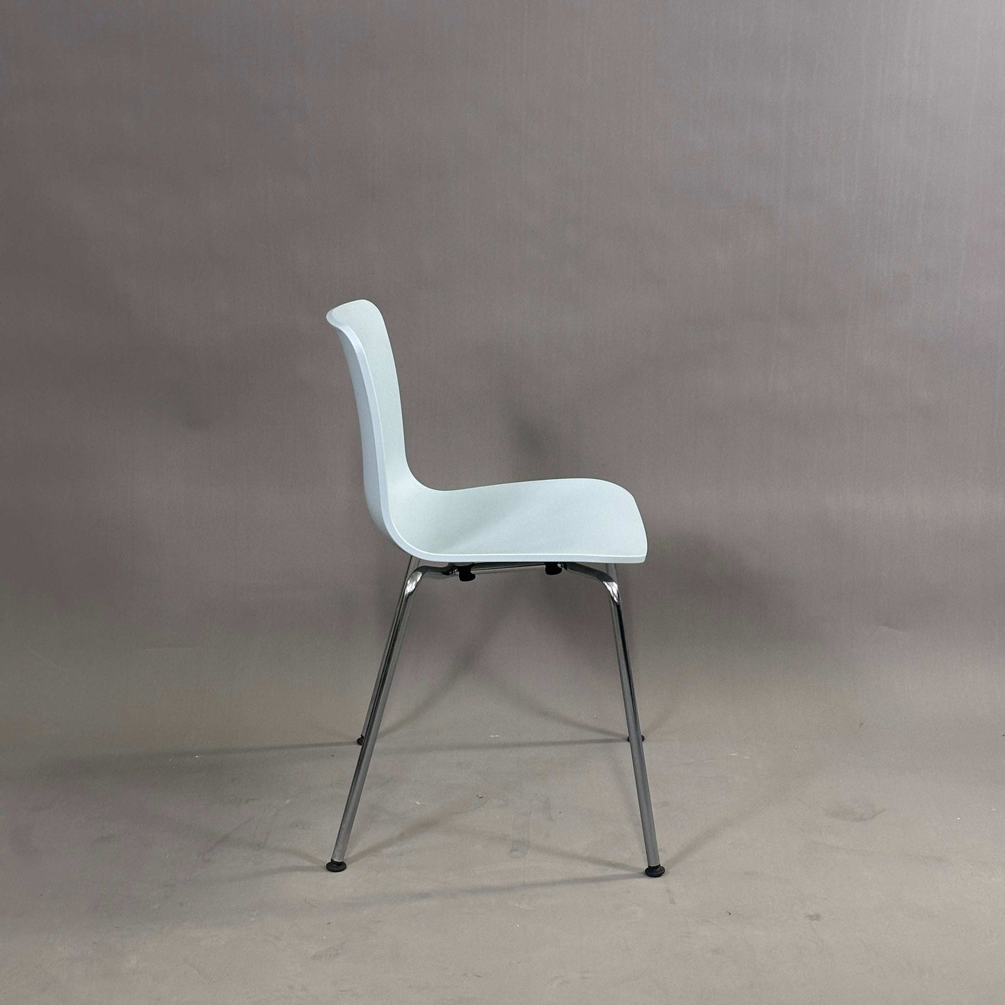 Vitra HAL Schalenstuhl mit eisblauer Kunststoffschale und verchromtem Metallgestell, Seitenansicht vor grauem Hintergrund