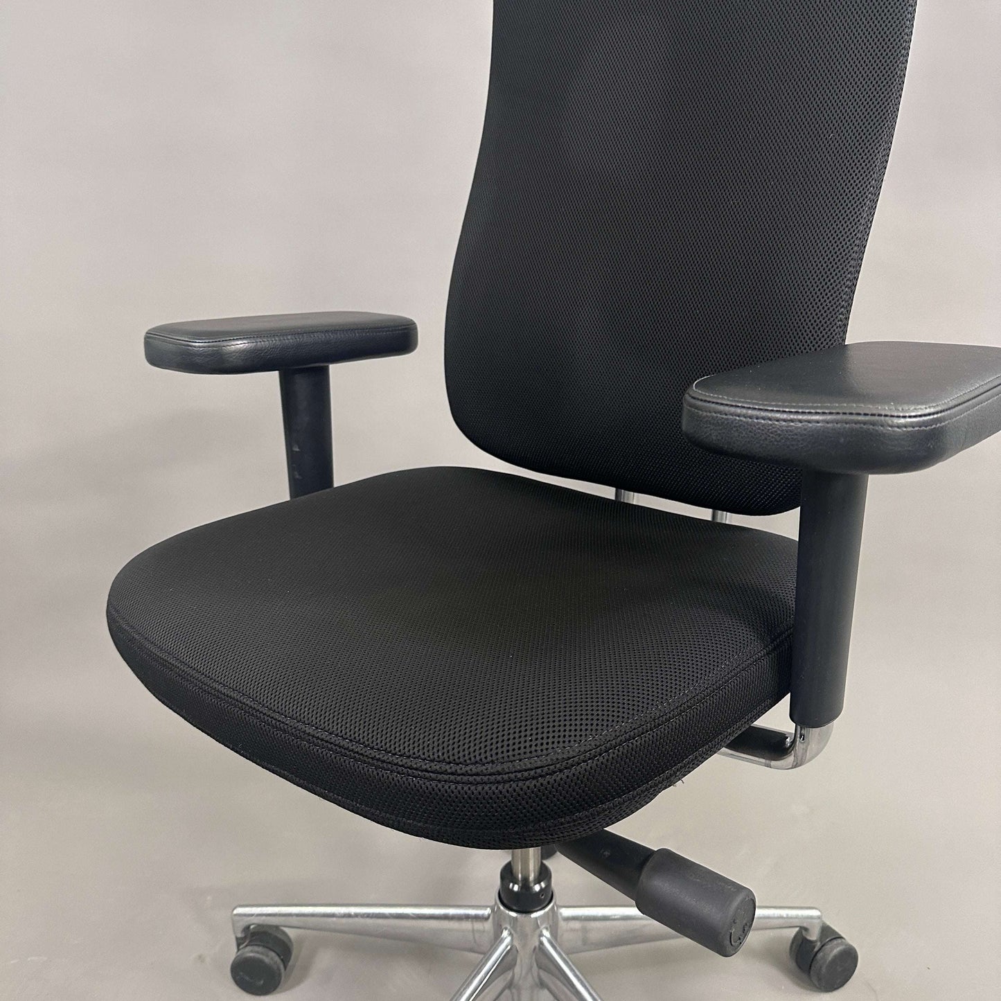 Vitra Headline black office chair with fabric seat, leather headrest, adjustable armrests, and chrome base