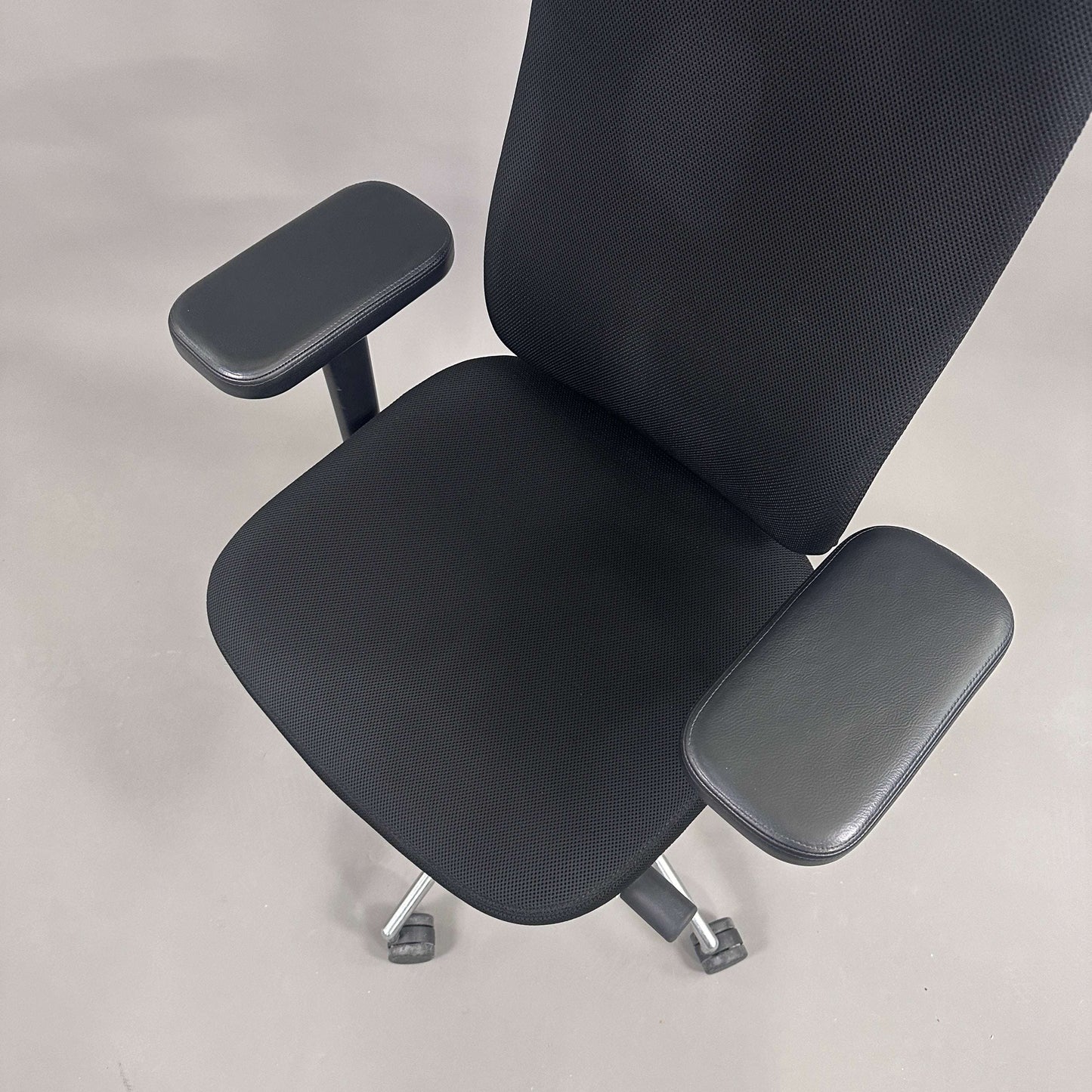 Vitra Headline black office chair with fabric seat, leather headrest, adjustable armrests, and chrome frame