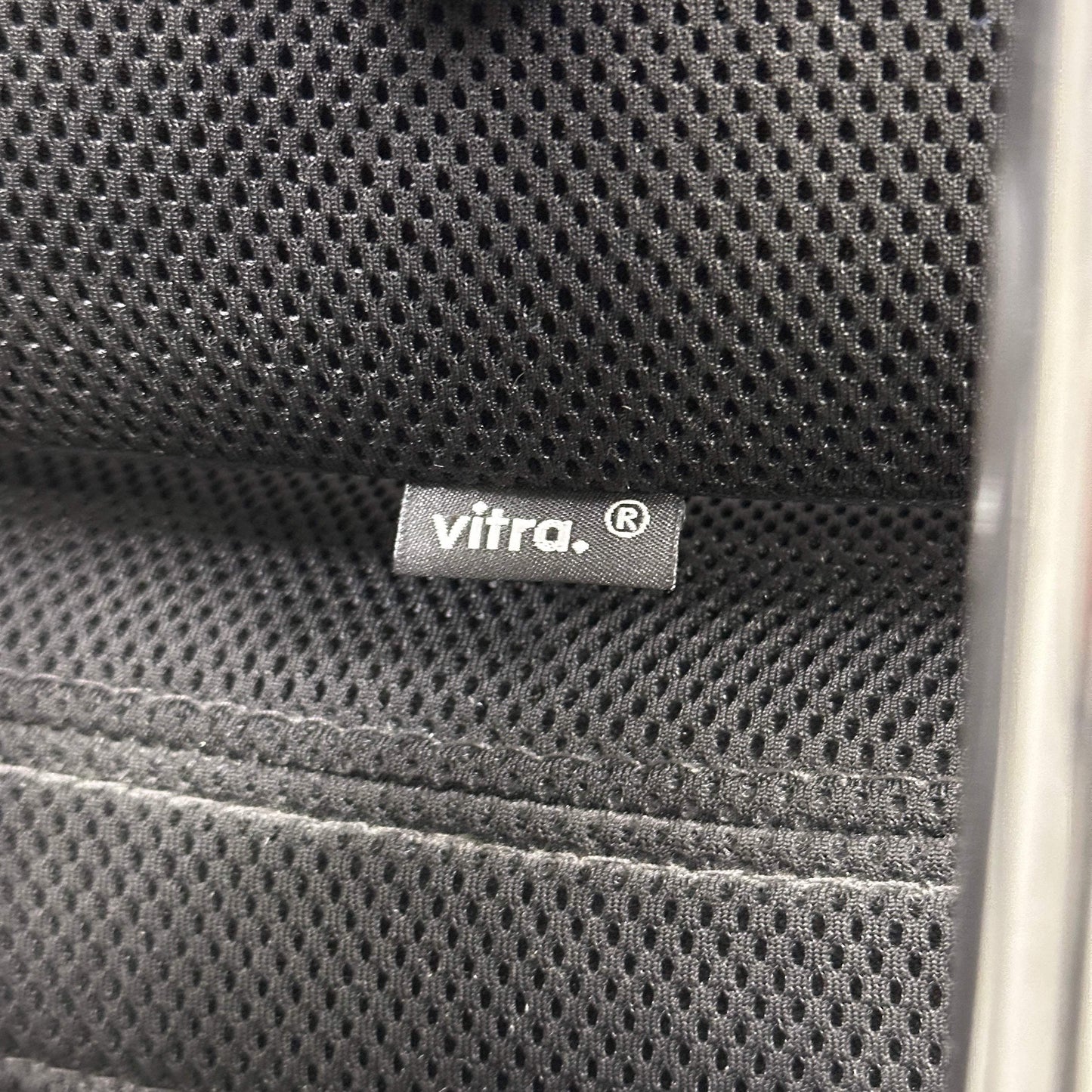 Close-up of black mesh fabric with Vitra brand label on the Vitra Headline office chair