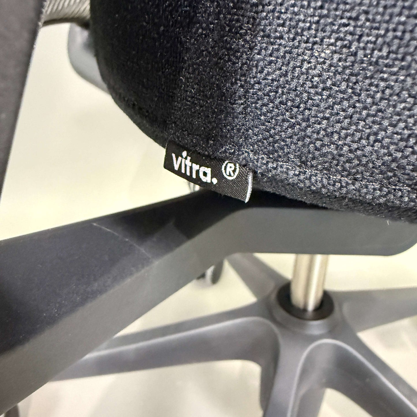 Close-up of Vitra ID Mesh office chair fabric and base with black seat and grey mesh backrest.