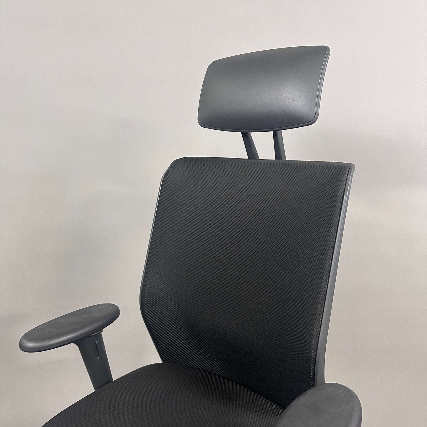 Schwarzer Vitra ID Mesh Bürostuhl mit Kopfstütze und verstellbaren Armlehnen, Sitzhöhe, Sitztiefe und Rückenlehne.