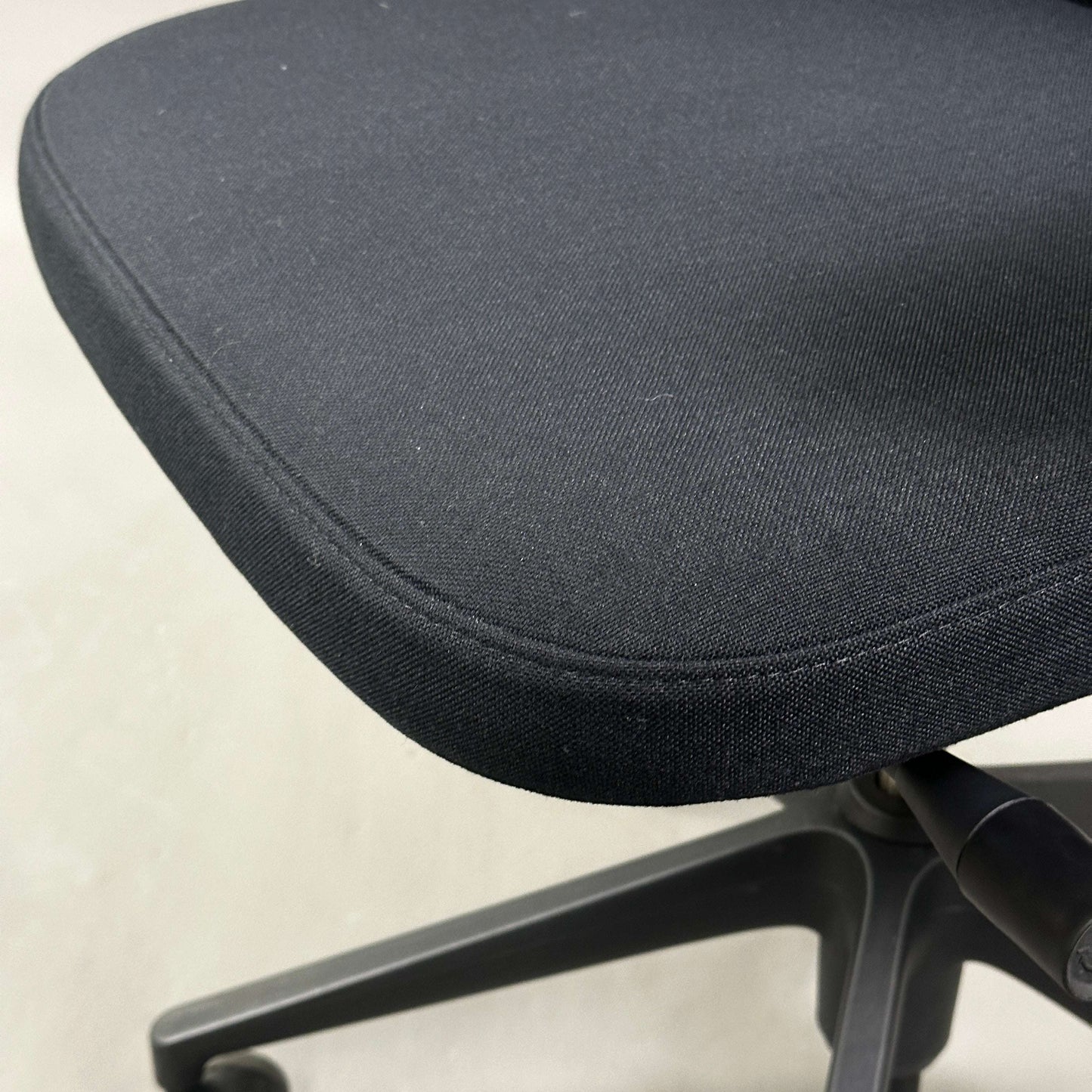 Close-up of Vitra ID Mesh black office chair with fabric seat and black plastic base