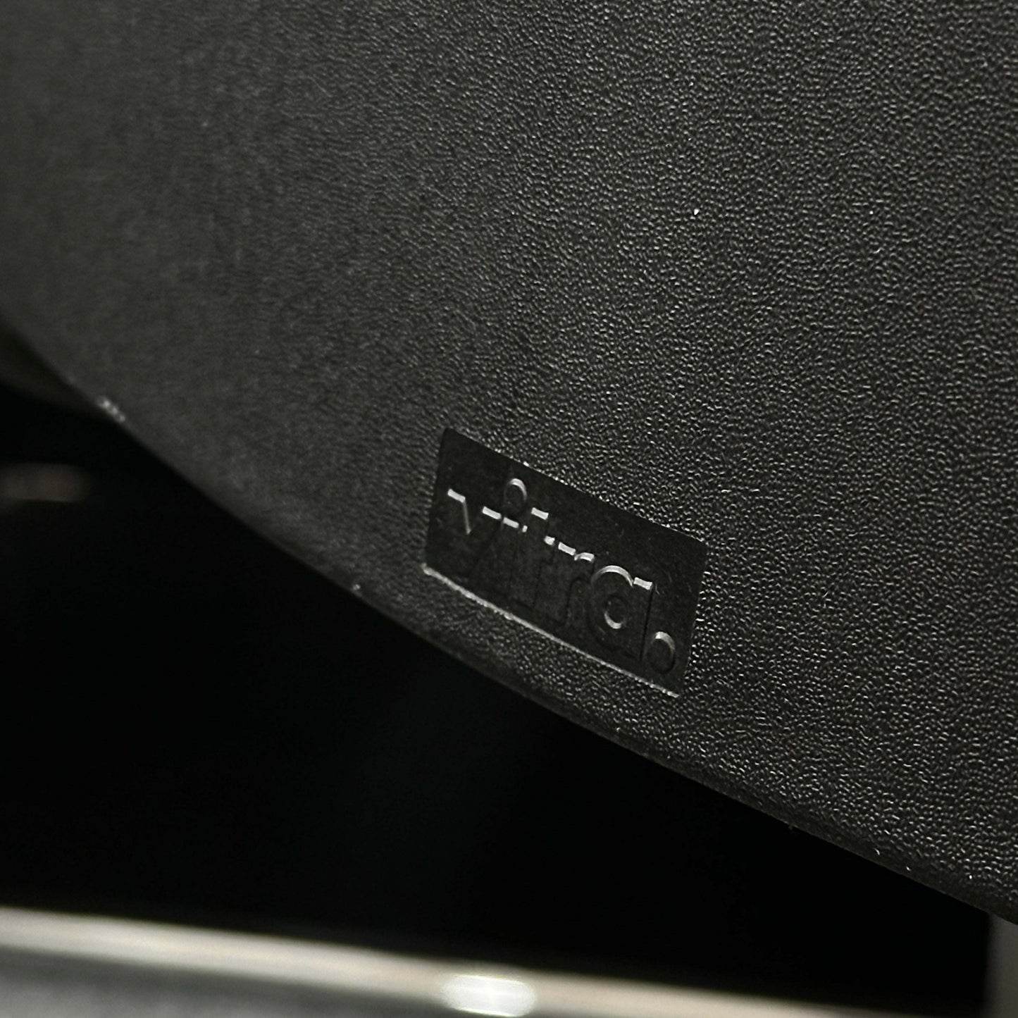 Close-up of the black Vitra ID Soft office chair with fabric cover and black plastic base highlighting ergonomic design.