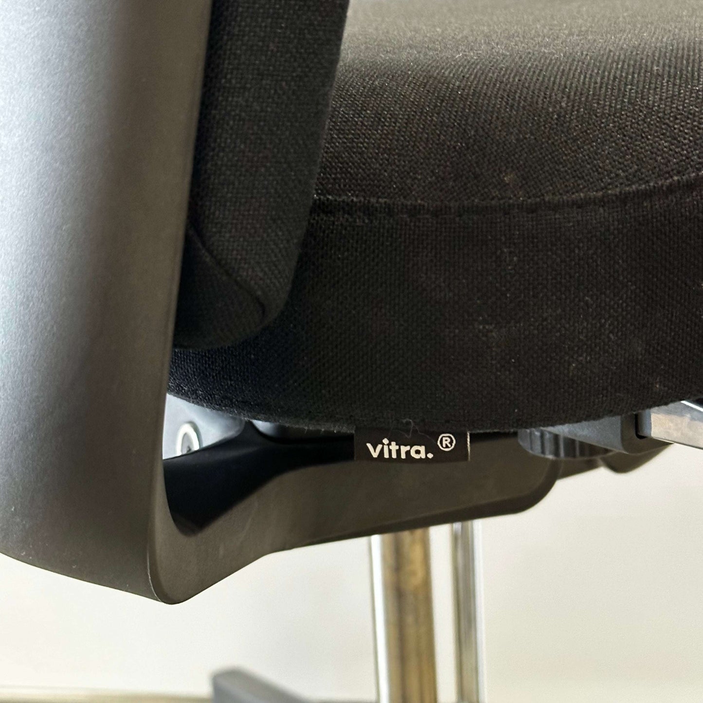 Close-up of black Vitra ID Soft office chair fabric and base with logo tag