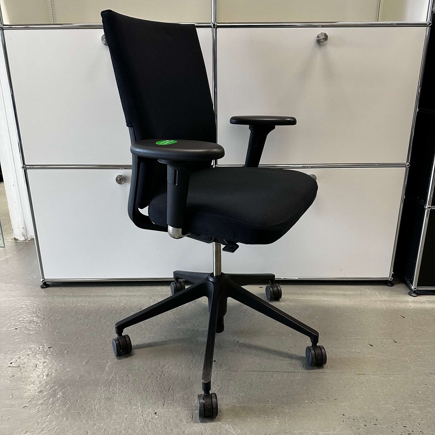 Black Vitra ID Soft ergonomic office chair with fabric upholstery and adjustable armrests on black plastic base with wheels