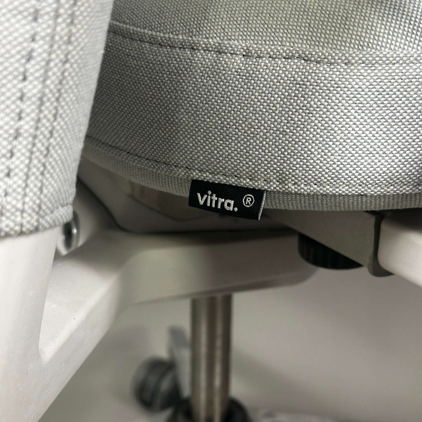 Nahaufnahme des hellgrauen Vitra ID Trim Schreibtischstuhls mit Aluminiumrahmen und Stoffbezug