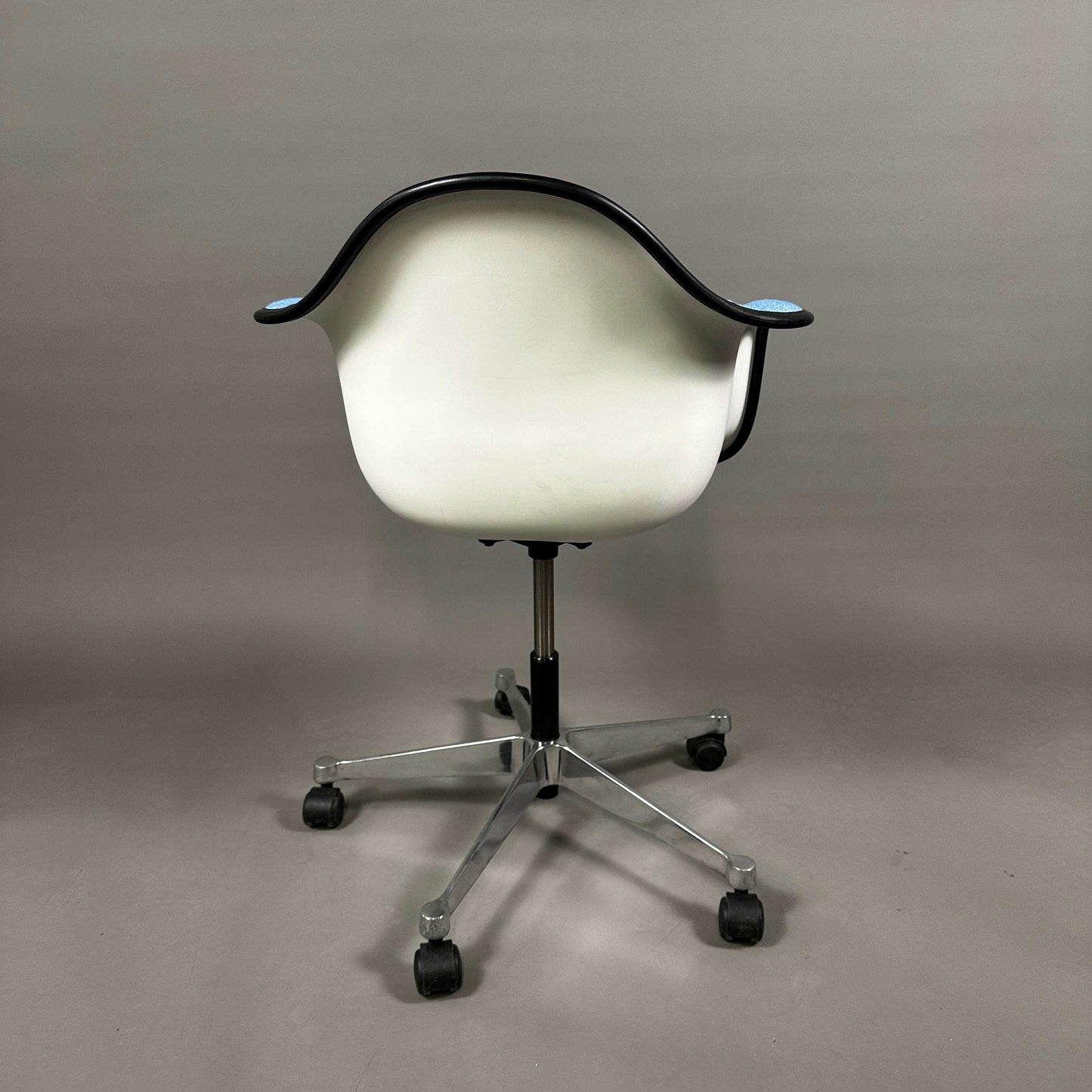 Vitra PACC Plastic Arm Chair mit weißer Sitzschale und blauem Hopsak Stoffbezug auf Rollgestell
