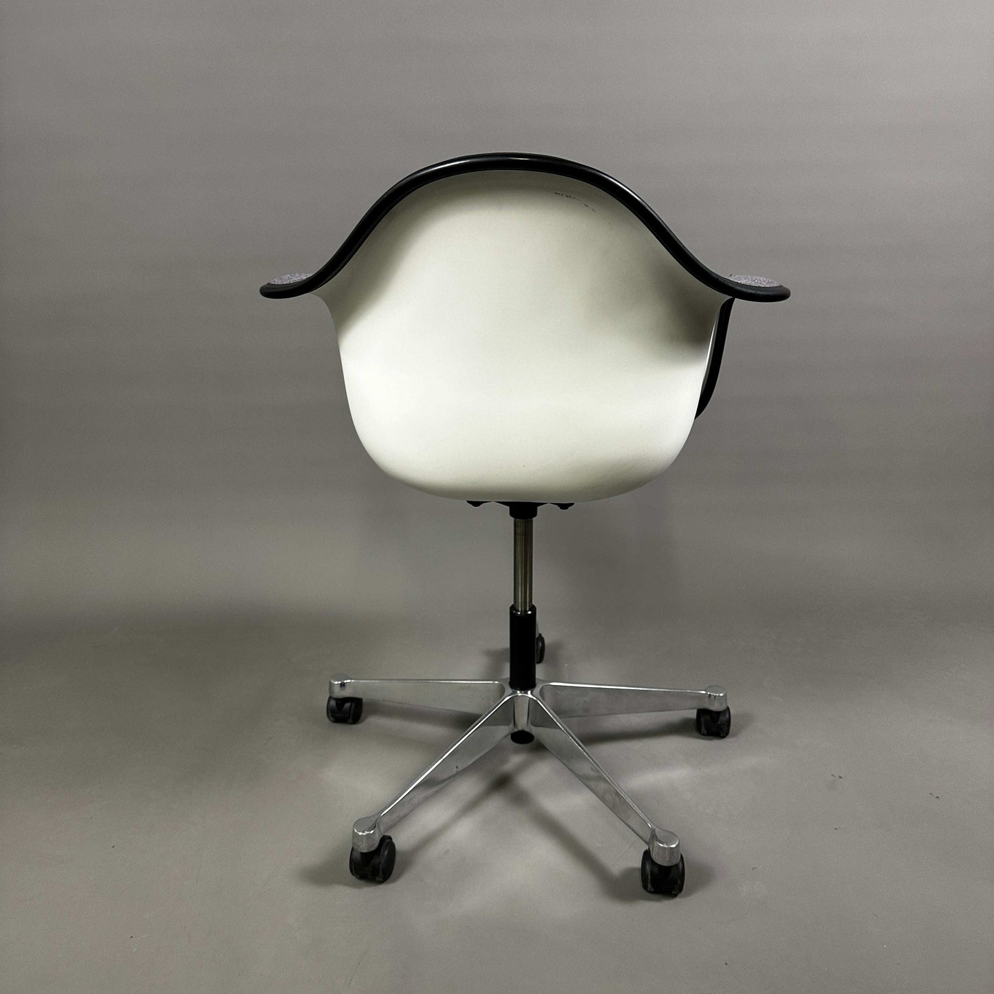 Vitra PACC Plastic Arm Chair mit weißer Sitzschale, grauem Hopsak Stoffbezug und schwarzem Rahmen auf Rollen
