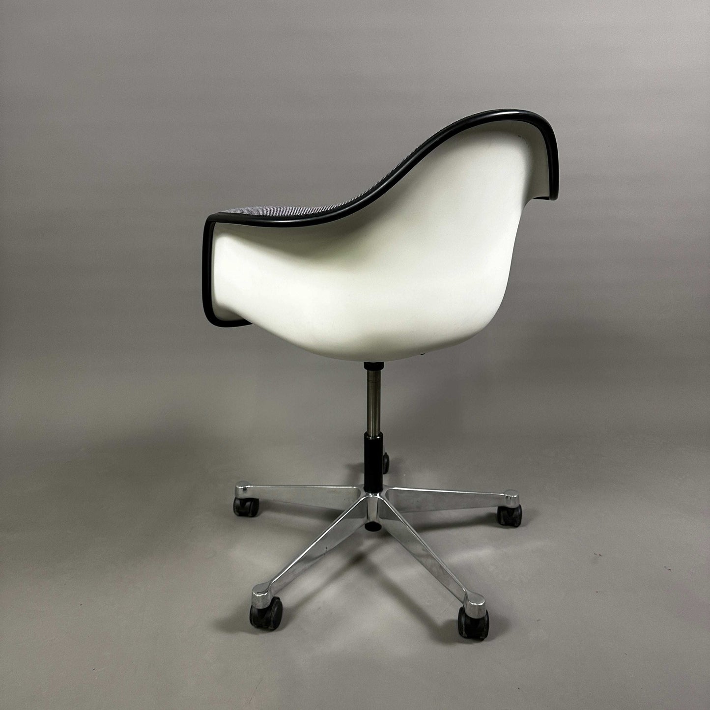 Vitra PACC Plastic Arm Chair mit weißer Kunststoffschale und grauem Hopsak Stoffbezug auf Rollenstuhlgestell aus Metall