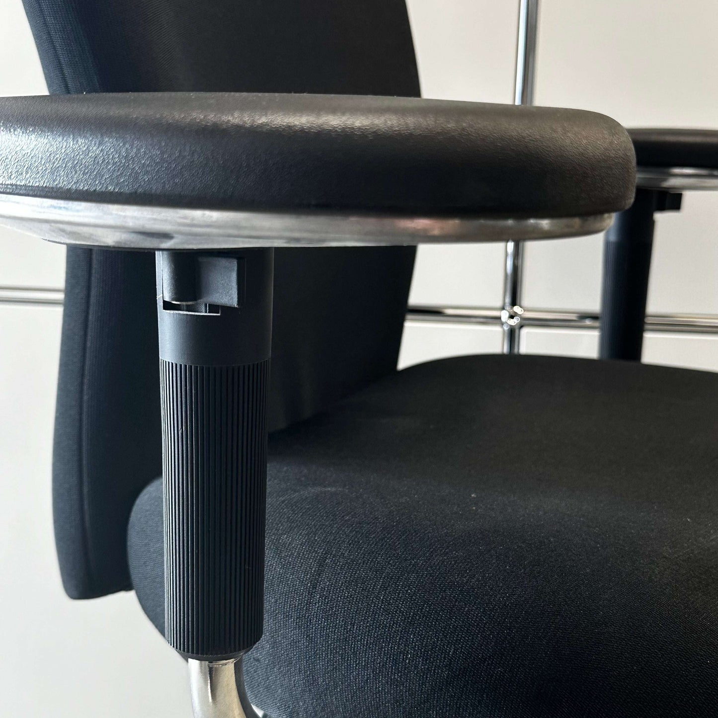 Close-up of the black Vitra T-Chair armrest and seat showcasing its modern design and ergonomic comfort