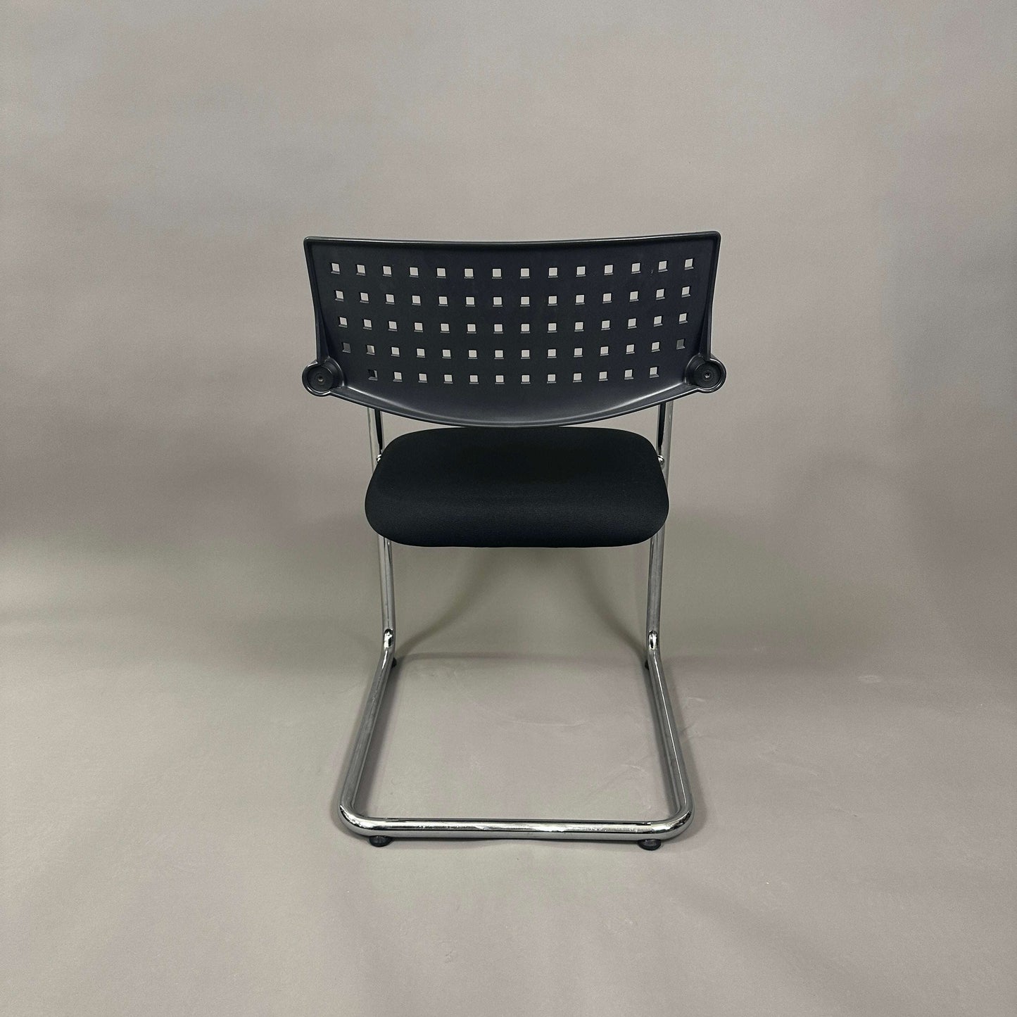 Vitra Visavis 1 black stackable chair with chrome frame and perforated backrest