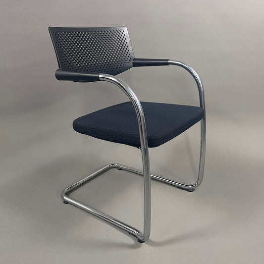 Vitra Visavis 2 black visitor chair with black fabric seat, perforated black plastic backrest, and chrome frame