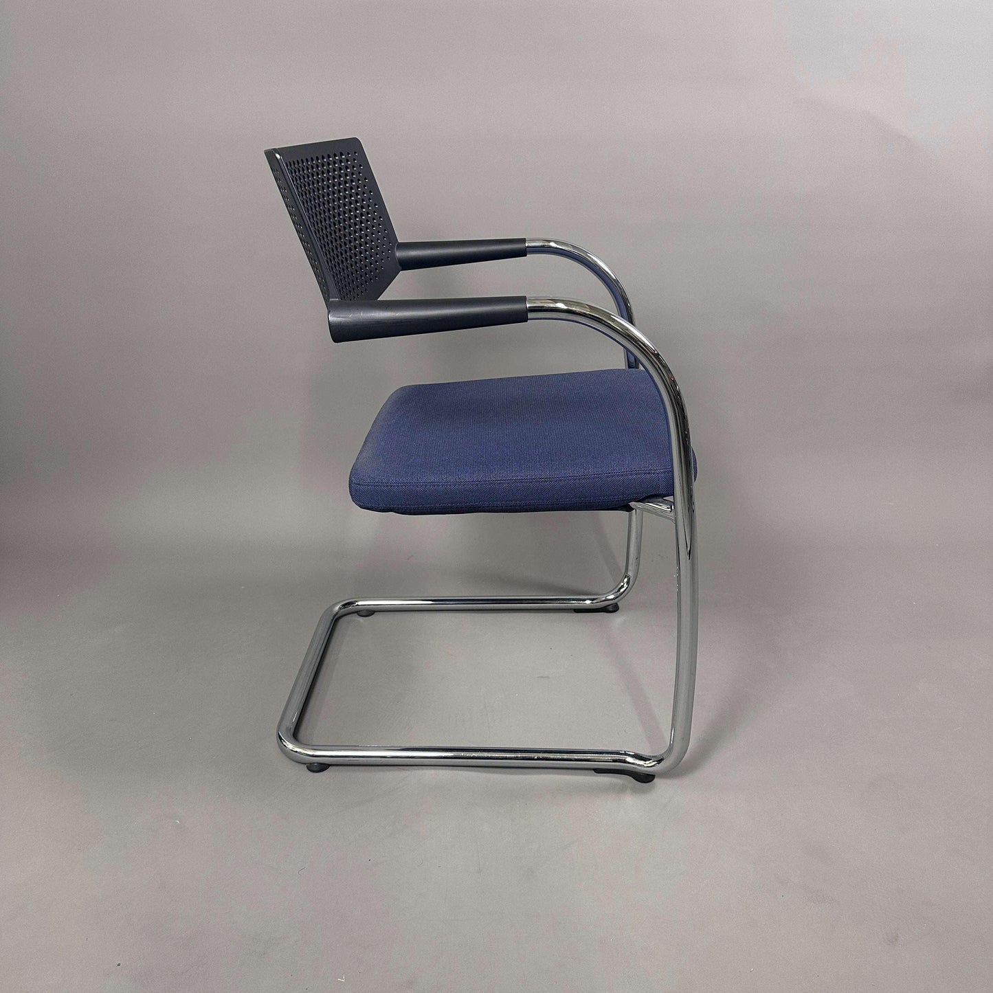 Vitra Visavis 2 Stuhl mit blau gepolsterter Sitzfläche, schwarzer Kunststoffrückenlehne und chromgestell, stapelbar