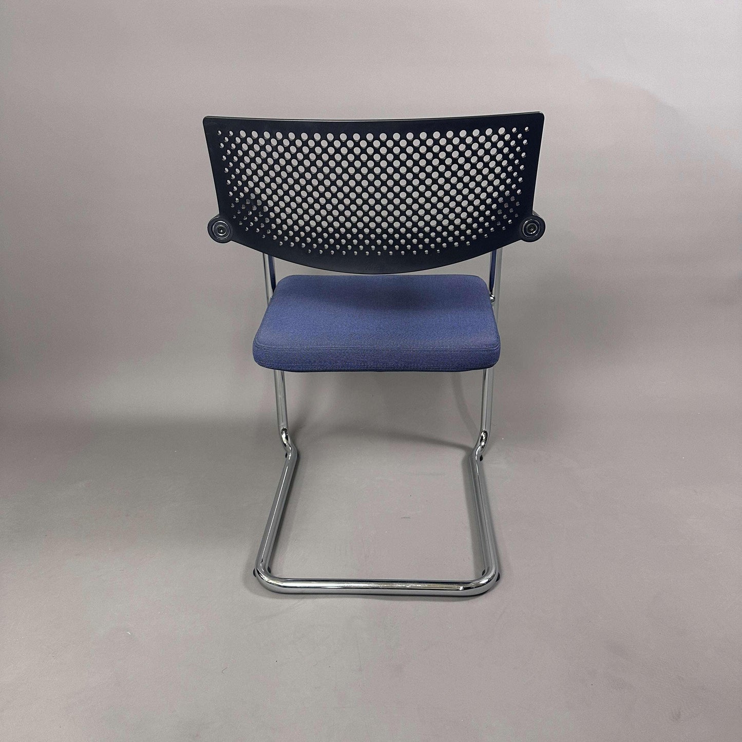 Vitra Visavis 2 Stuhl mit schwarzer Kunststoffrückenlehne, blauem Polstersitz und chromgestell, stapelbar