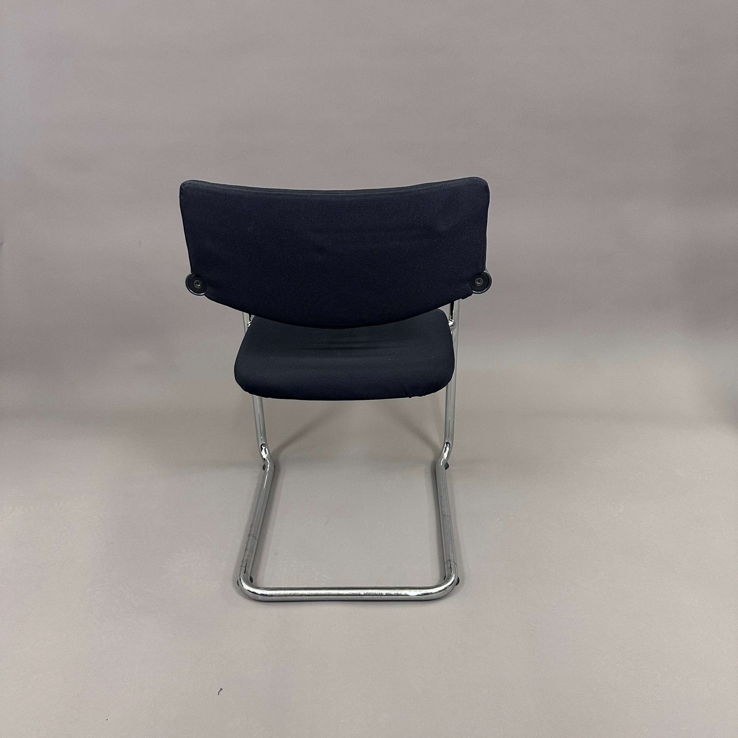 Vitra Visavis Softback chair with black fabric upholstery, padded backrest, chrome frame, and plastic armrests, cantilever design.
